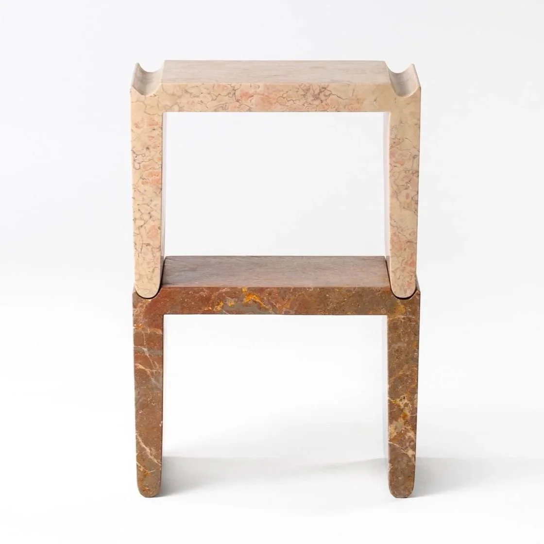 A chair made of two different types of marble with a modern design, featuring a curved backrest and straight legs.