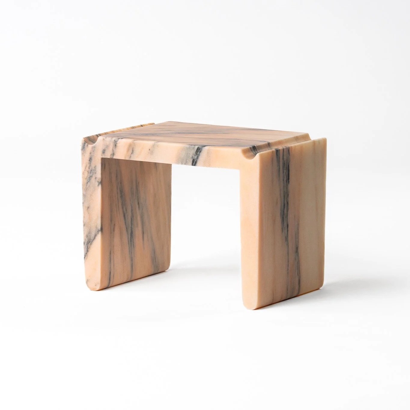 Small marble side table with a rectangular shape, featuring a beige and black veined pattern, set against a plain white background.