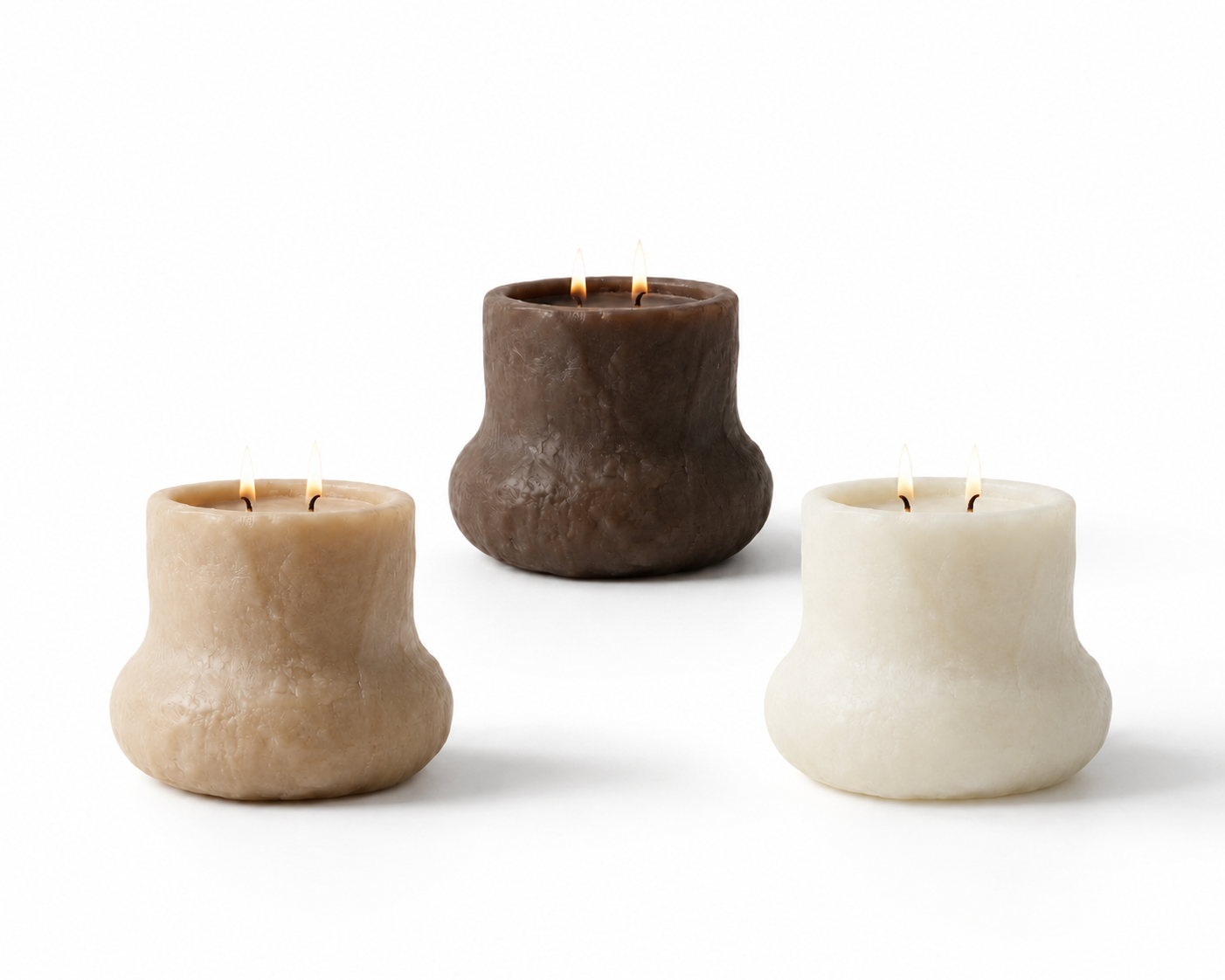 Three candle holders made of textured stone, each with two lit candles, placed on a white background.