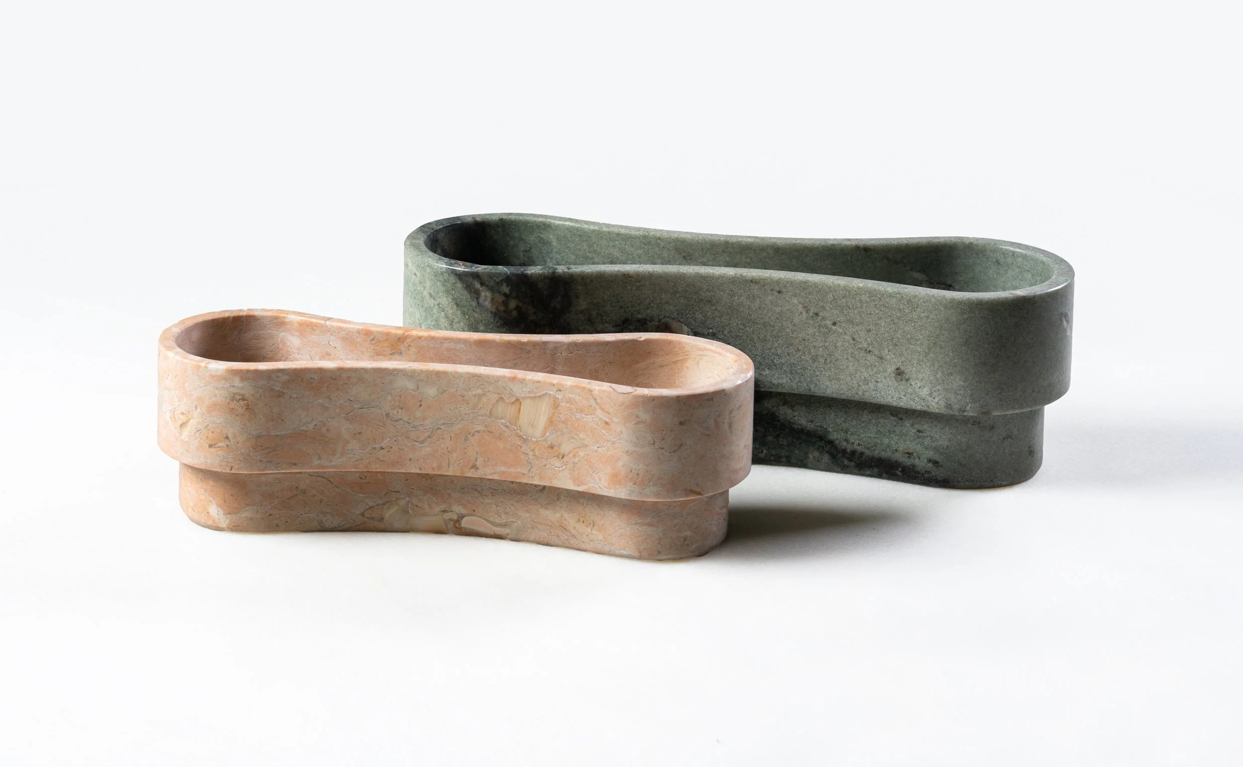 Two marble tissue holders, one pink and one green, stacked against a white background.