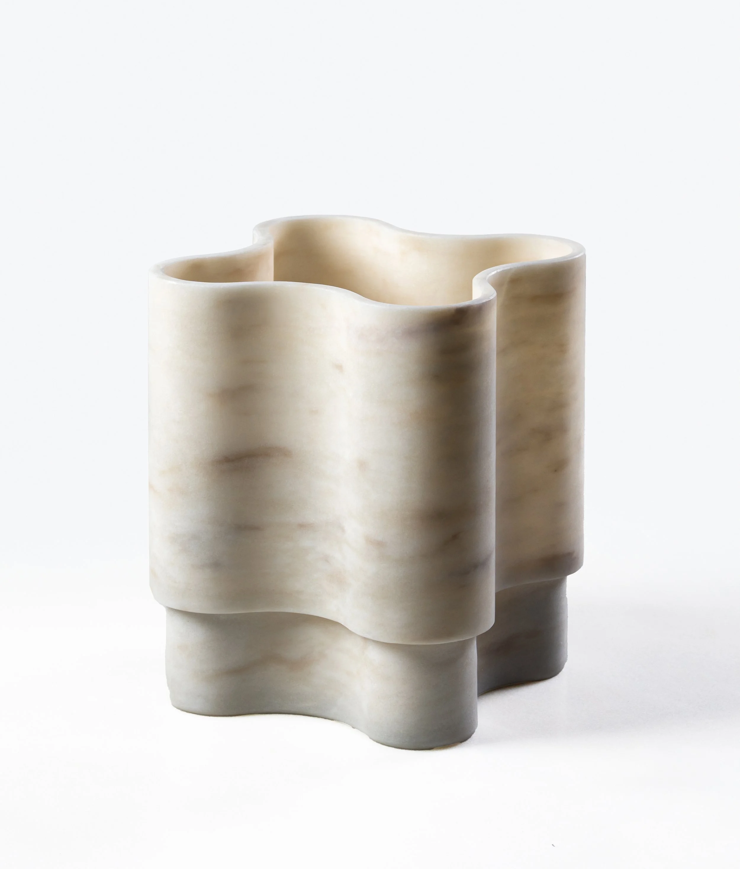 A marble vase with a modern, wavy design, standing on a white surface with a plain white background.