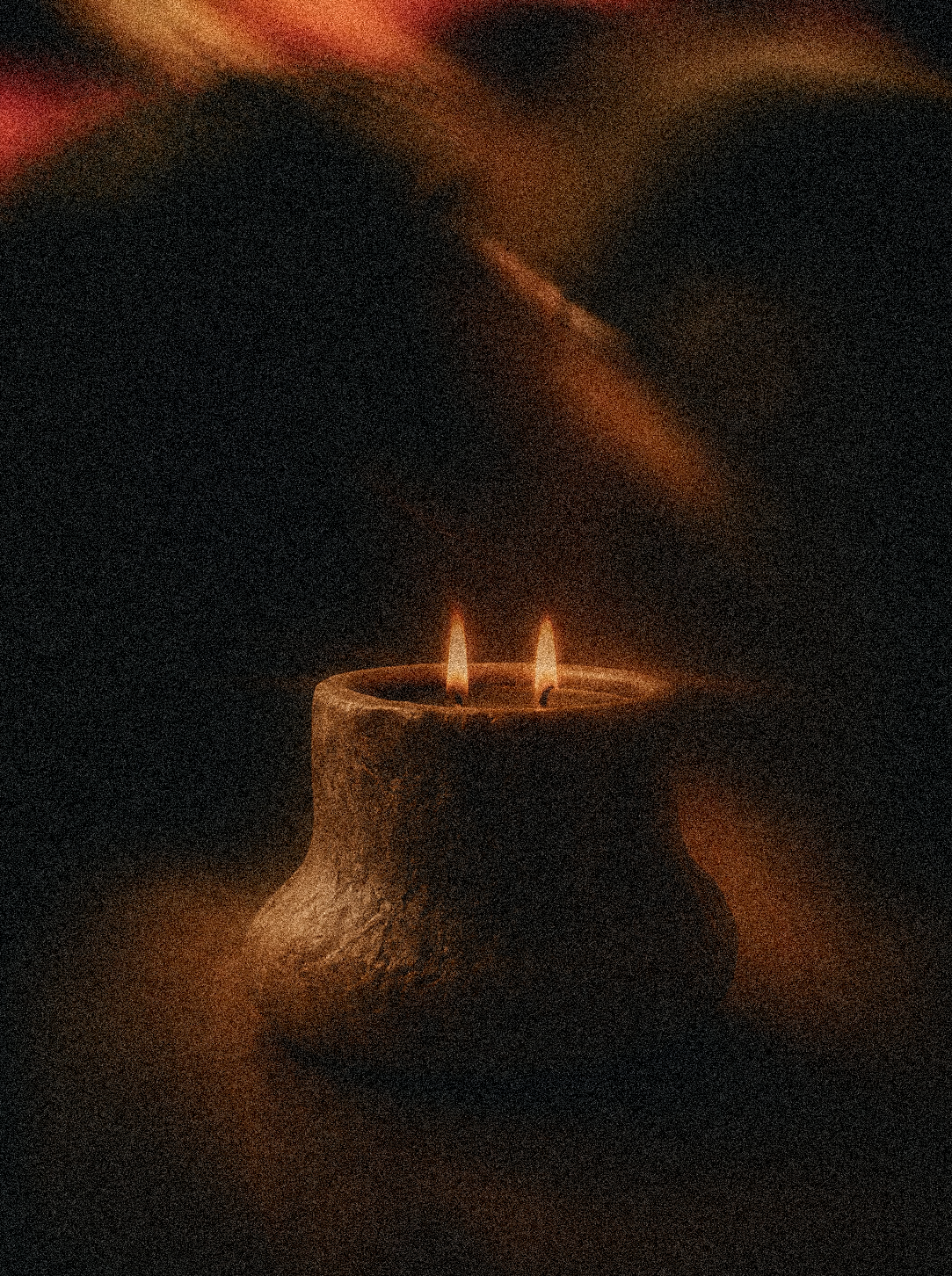 A candle with two flames in a dark setting.