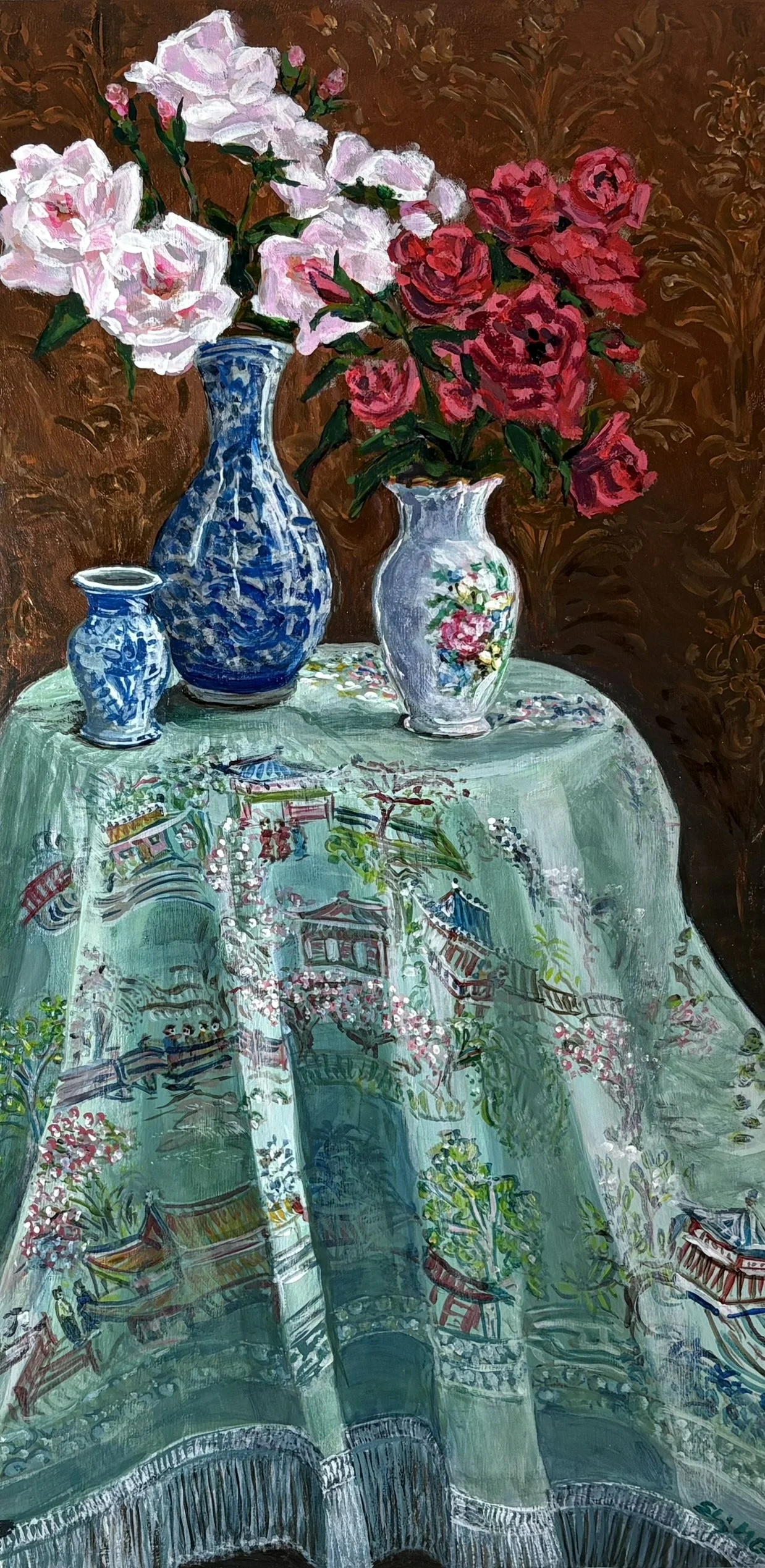 A still life painting of three vases with pink and red roses on a table covered with a silk cloth featuring a landscape scene.