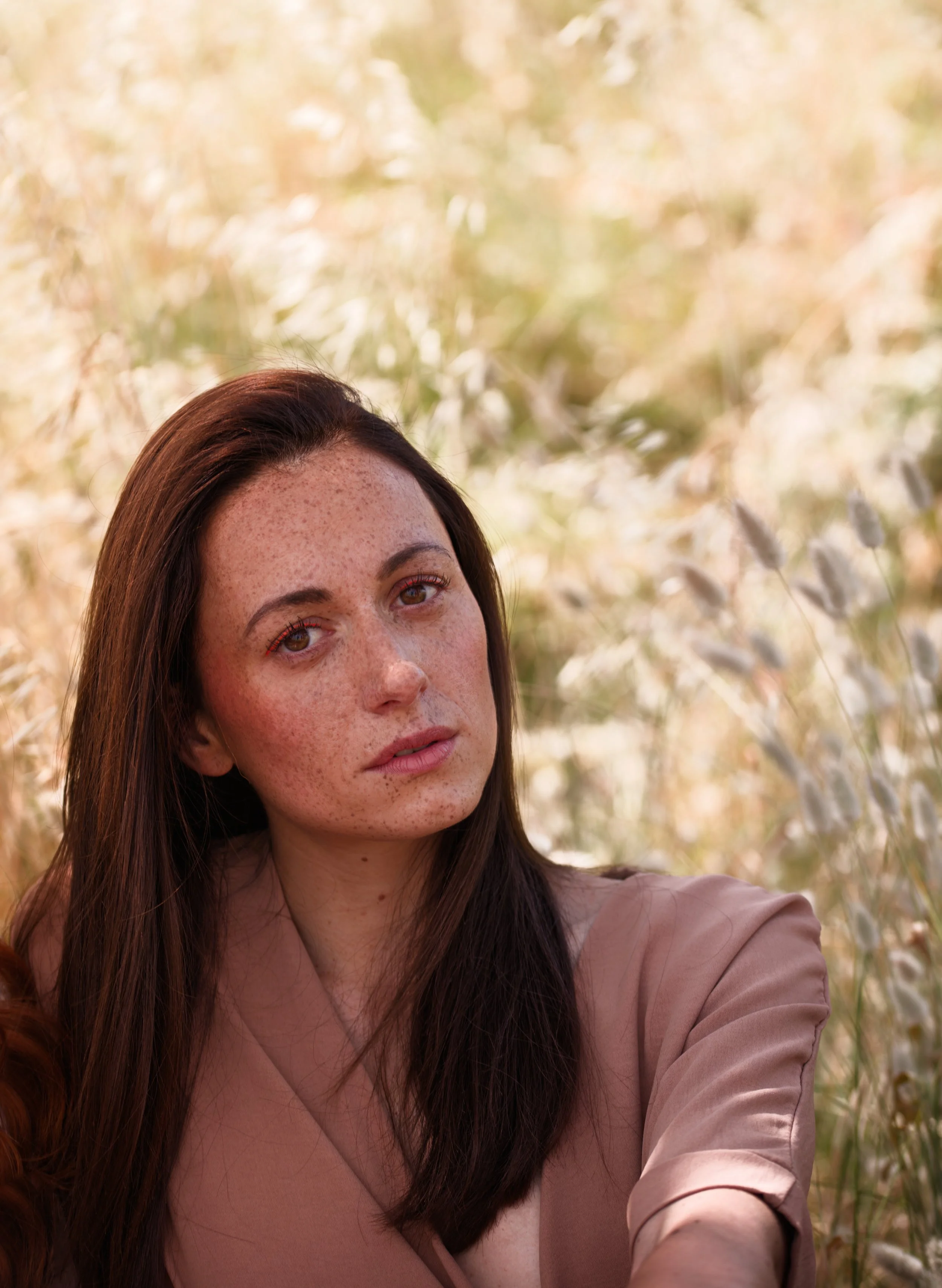 photo portrait d'une jeune femme brune dans un champ