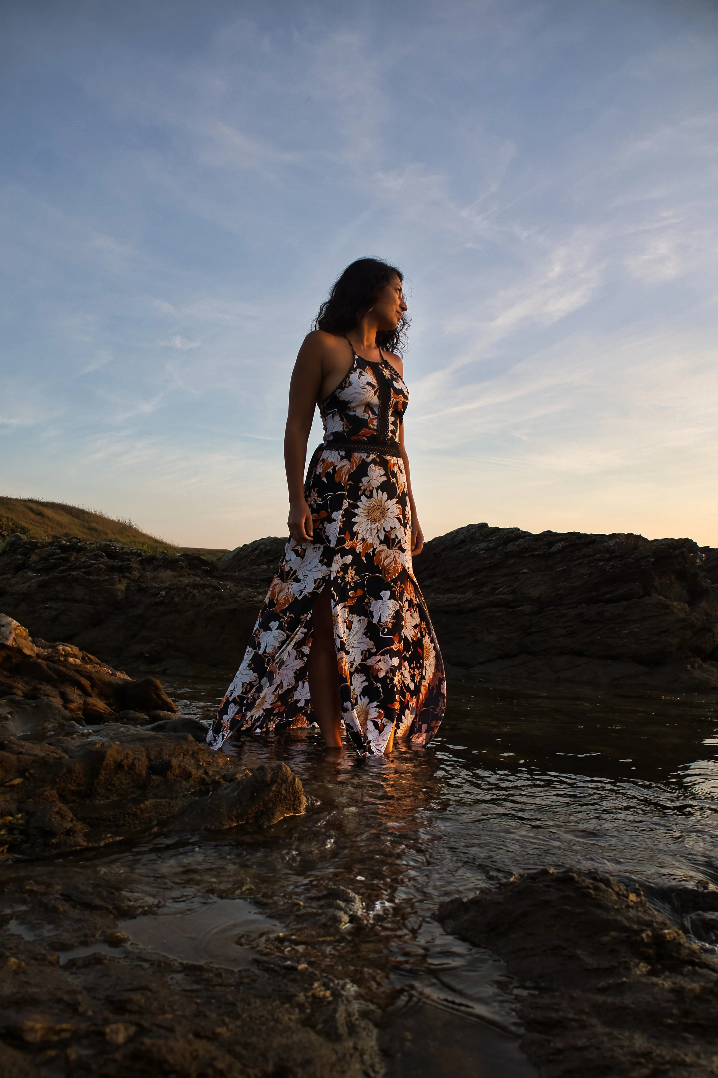 photo portrait d'une jeune femme les pieds dans l'eau au coucher de soleil