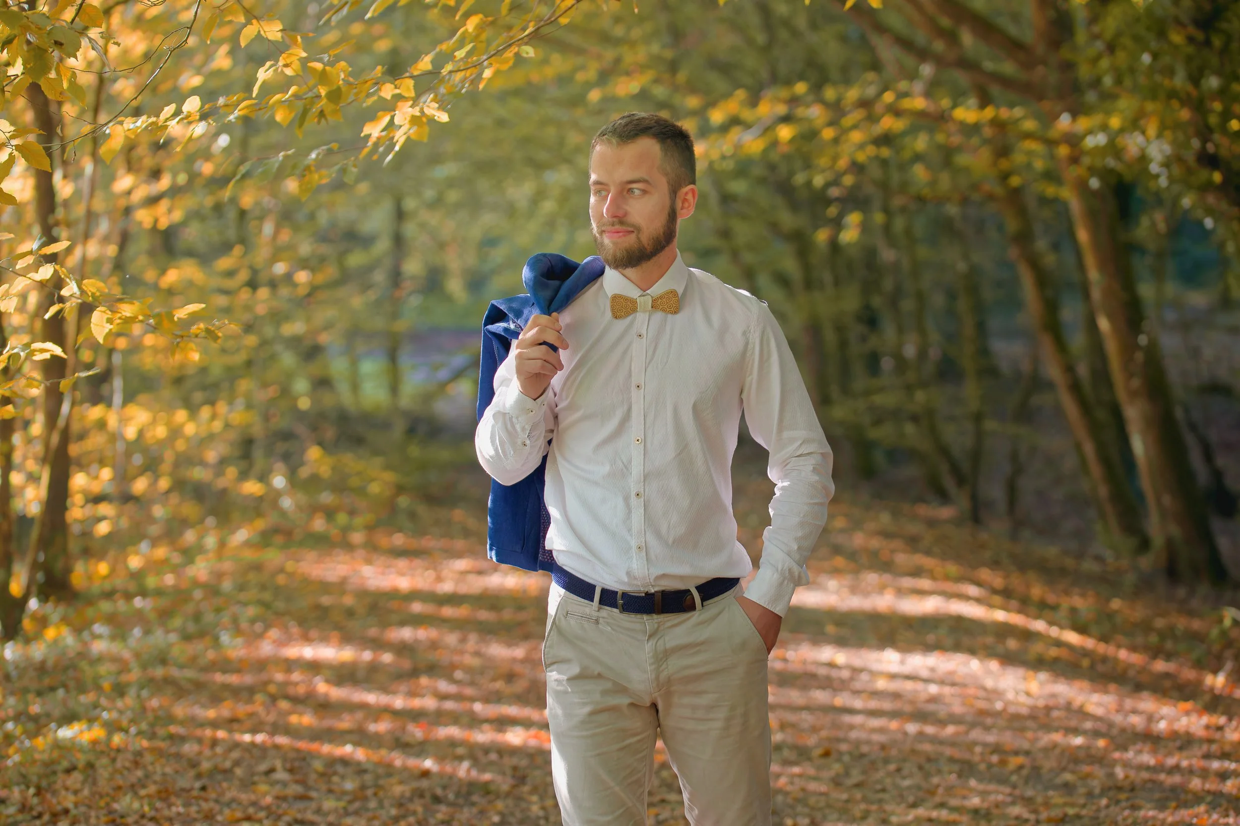 Photo portrait d'un jeune homme avec un noeud papillon marchant dans une forêt