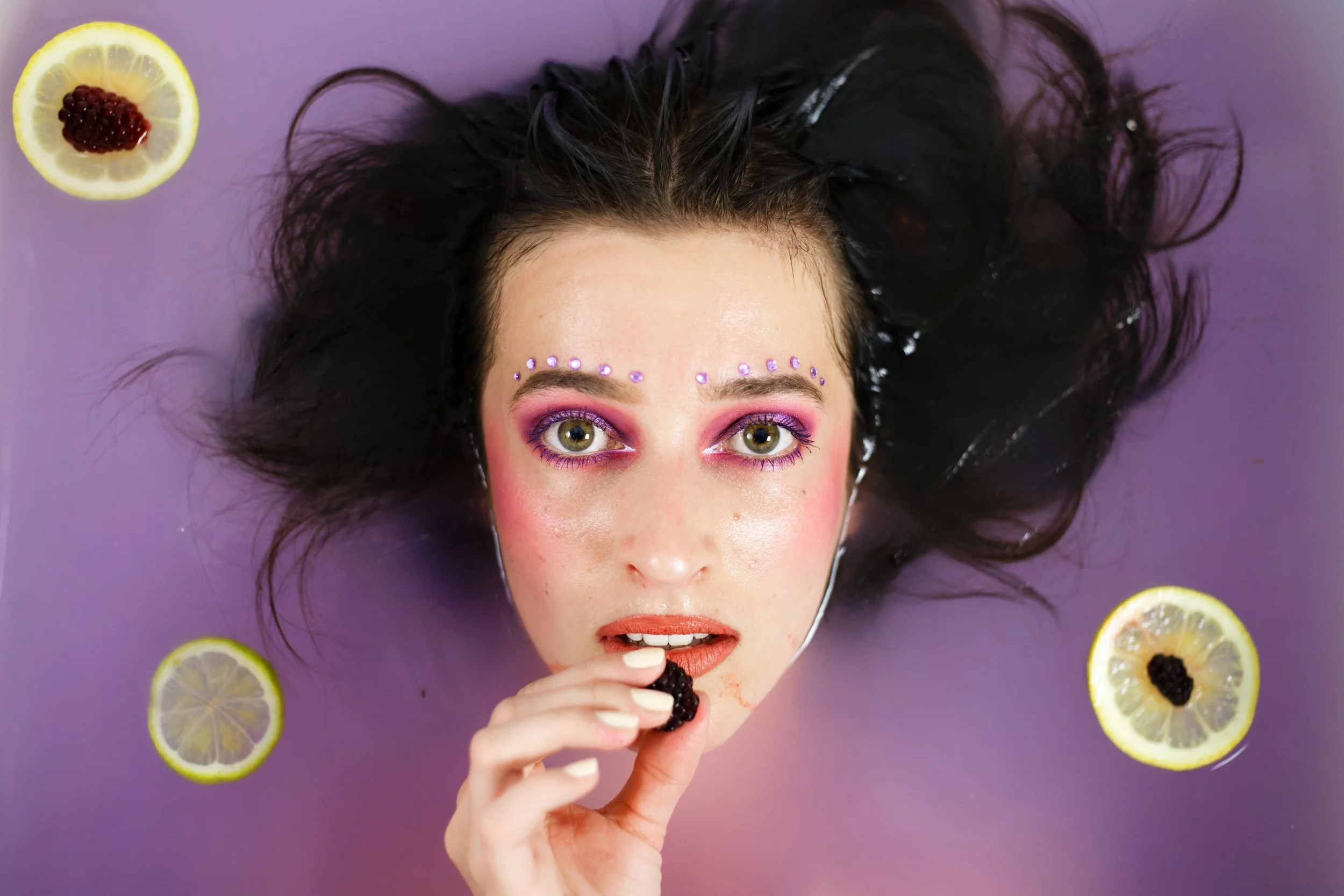 portrait photo d'une jeune femme dans un bain de lait violet