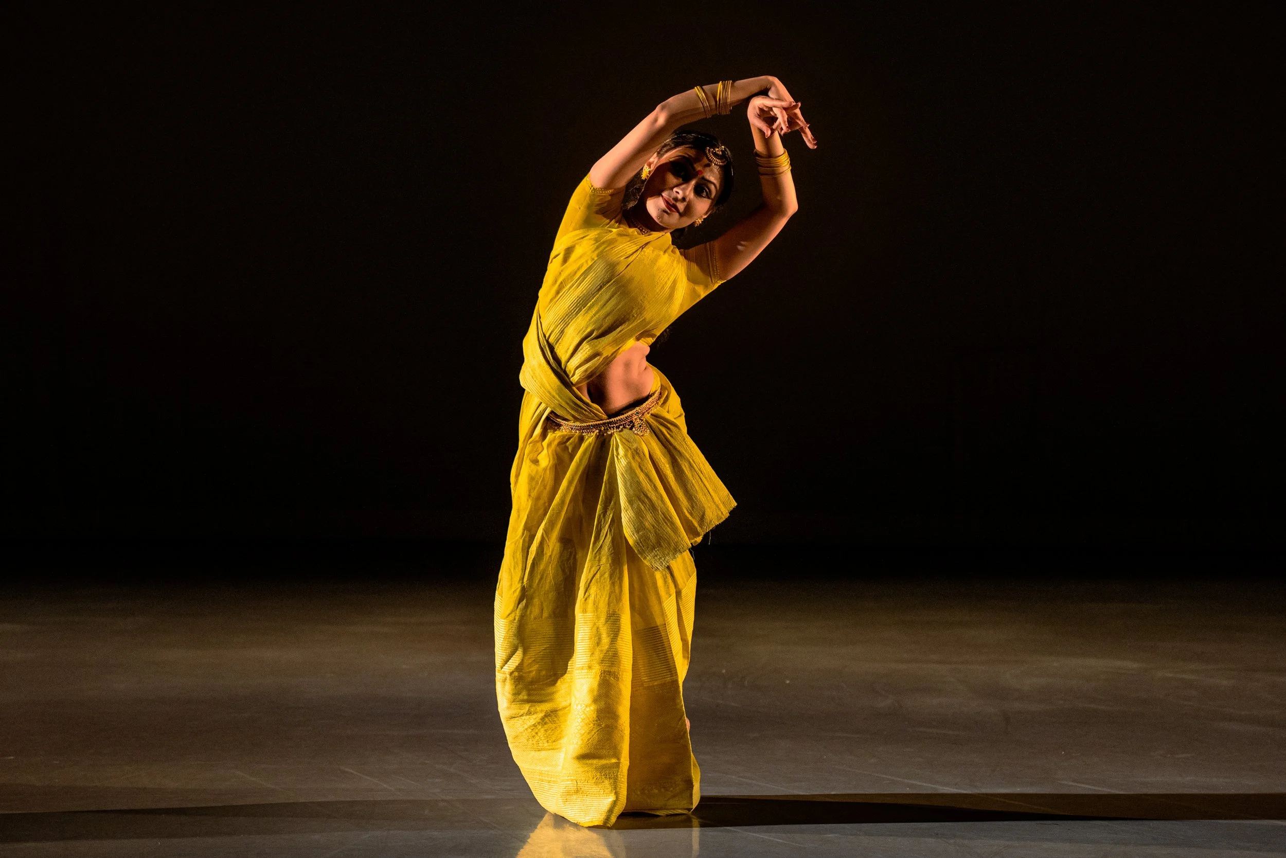 Kaustavi Sarkar on stage dancing in a yellow dress