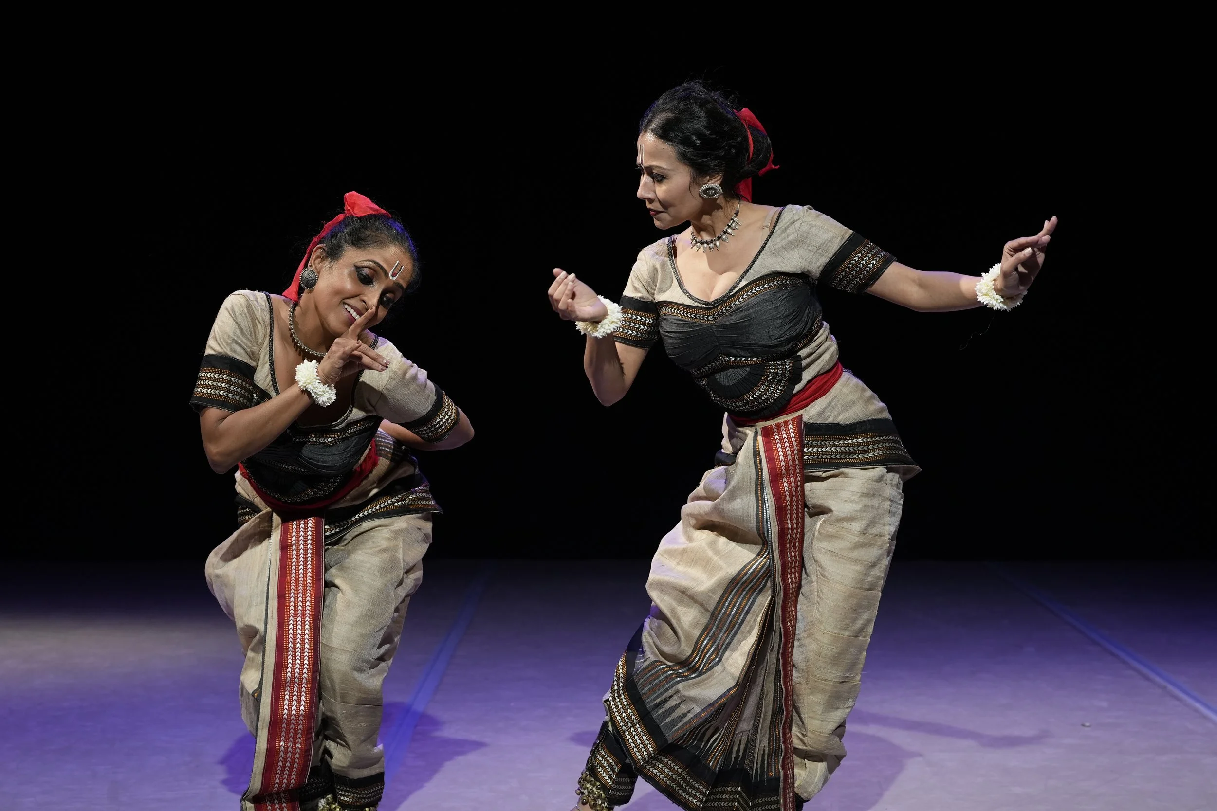 two dancers on stage looking at each other 