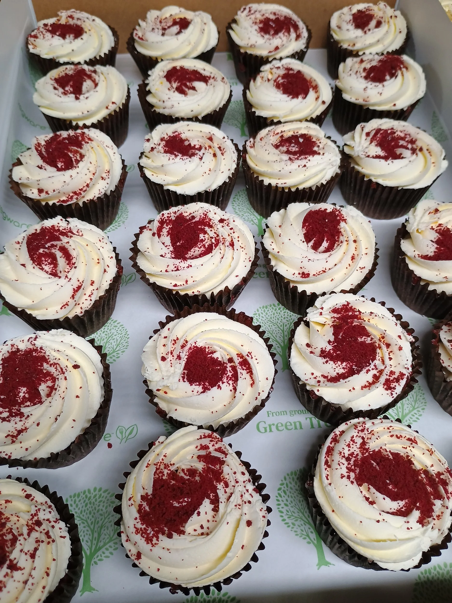 Cupcakes with white frosting, red sprinkles, and a swirl of frosting on top