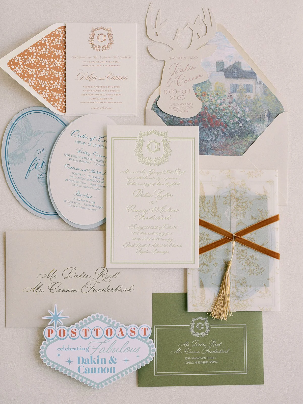 Collection of wedding invitations and stationery including an invitation with a gold crest, a save-the-date with a deer head silhouette, an order of service, a thank you card, an envelope with gold and white design secured with a brown ribbon and tassel, and various decorative cards.