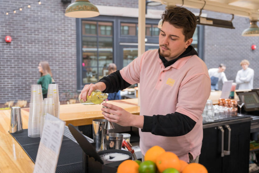 Lifestyle branding photography in Virginia featuring a bartender preparing a drink at an outdoor bar. Shot by OMGVA.com and SNKWORKS.com — a creative agency specializing in visual storytelling, branding content, and small business photography across