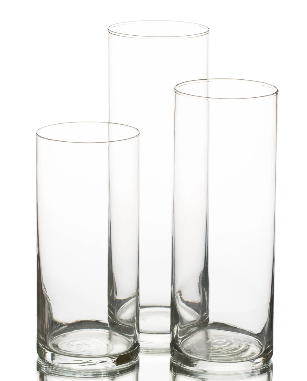 Three tall, empty, clear glass vases of different heights.