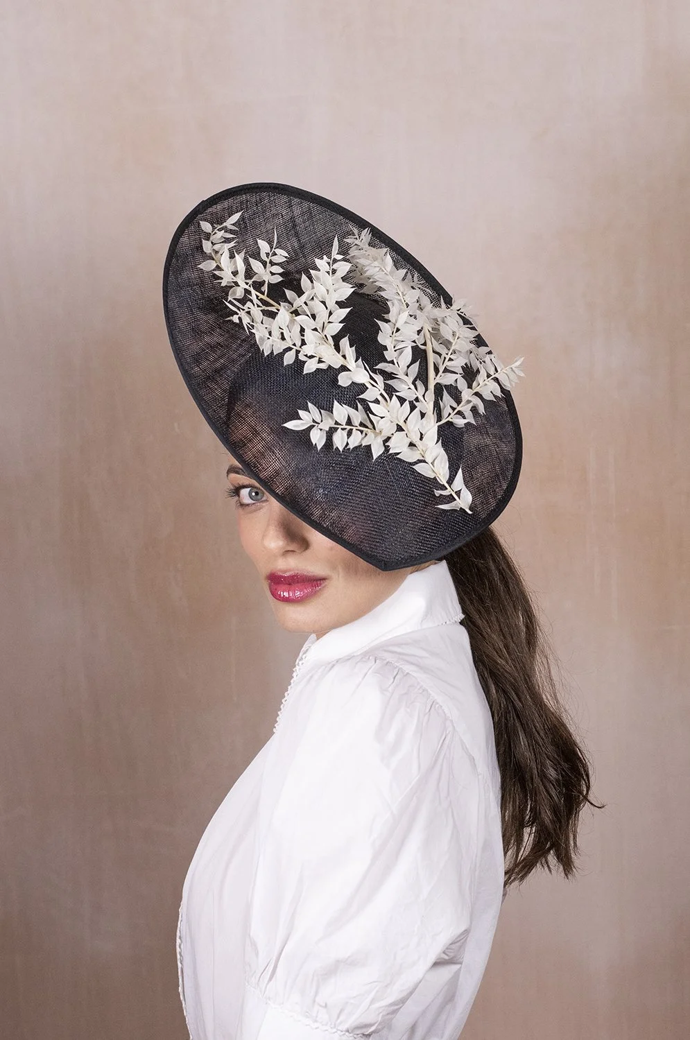 Stylish wedding guest wearing an elegant occasion hat