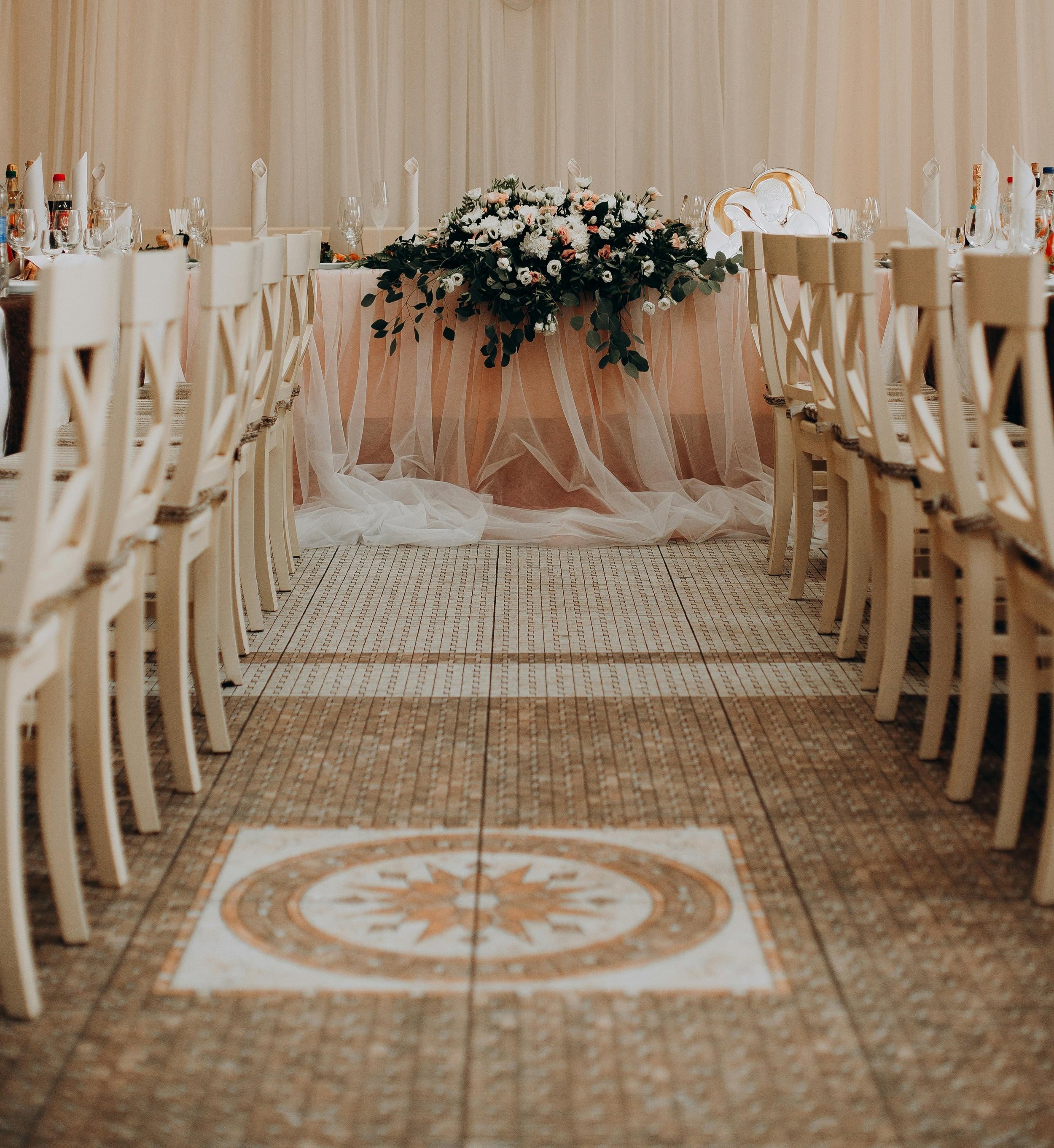 Virginia Beach wedding reception table with floral centerpiece and pink drapery backdrop.
