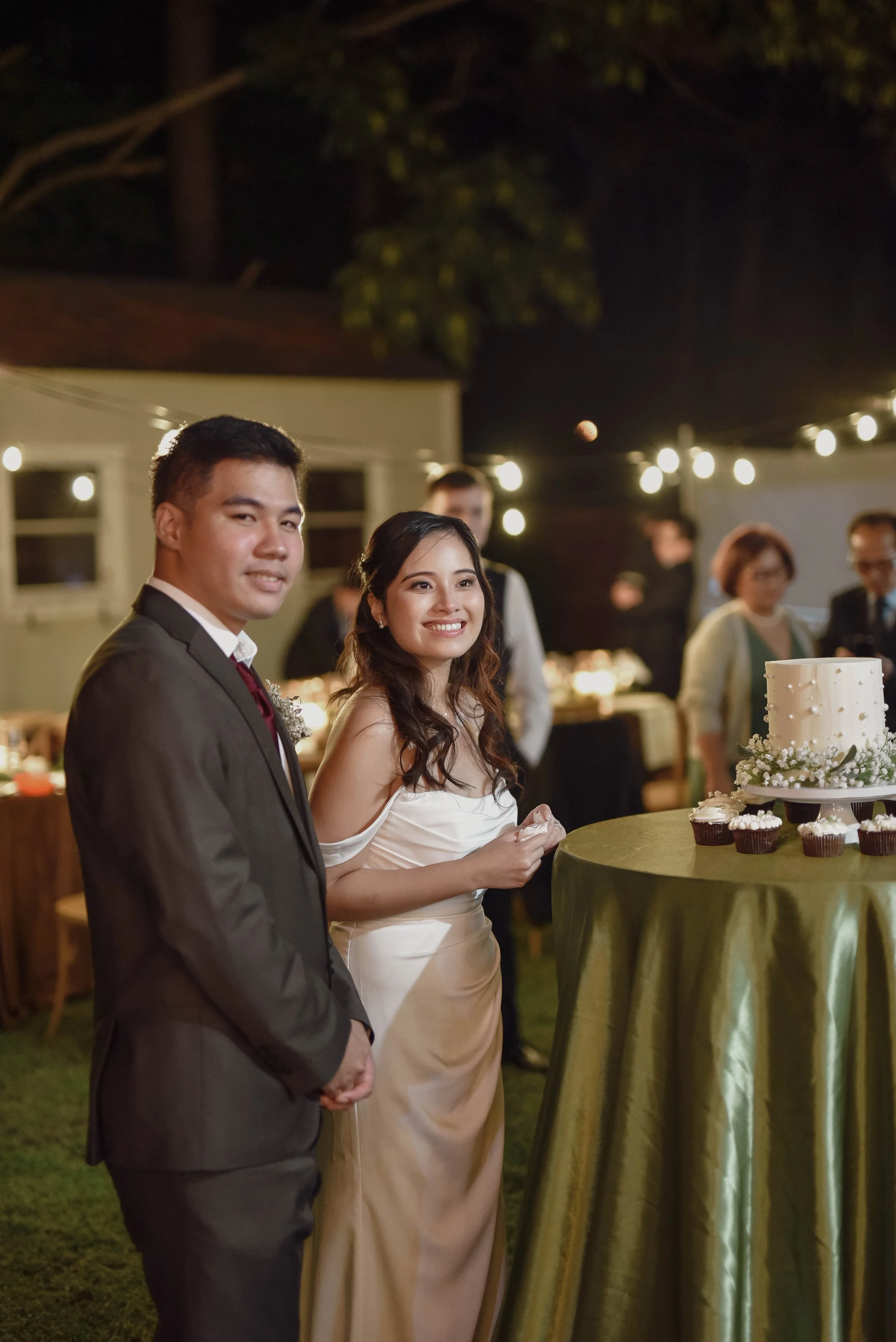 Virginia Beach couple in wedding attire standing in front of their cake table standing near wedding cake