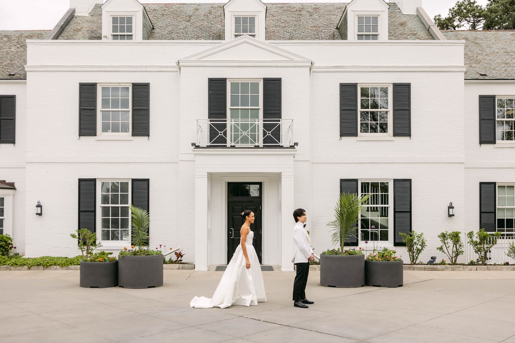 Bride and groom share a first look in front of Harding Waterfront Estate in Mississauga, Ontario before their outdoor wedding ceremony.