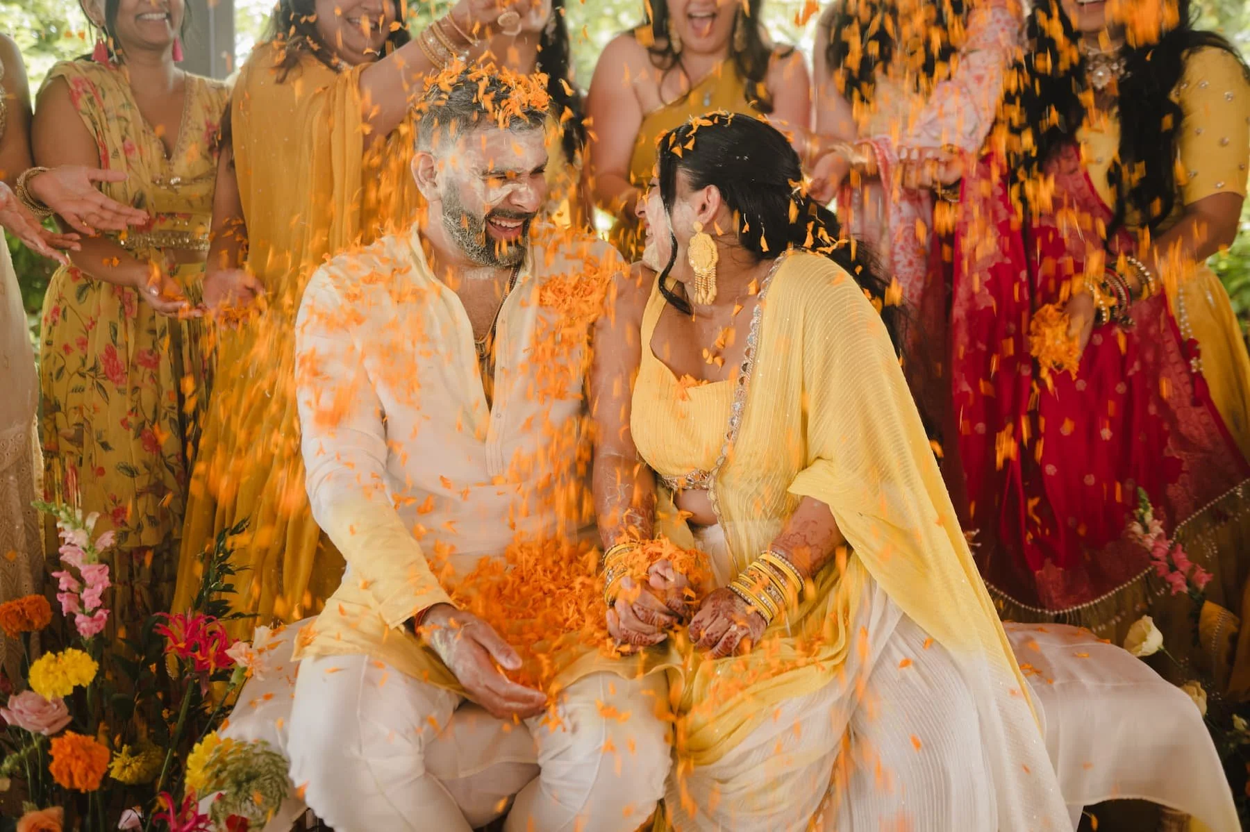 Guests laughing as groom Sagar is covered in Haldi paste during Ashika and Sagar's pre-wedding Haldi celebration at Arlington Estate.
