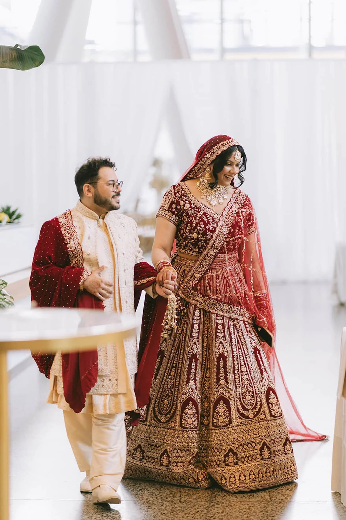 Bride and groom enter their wedding reception hand in hand during a modern Hindu wedding at Ricarda's in Toronto.
