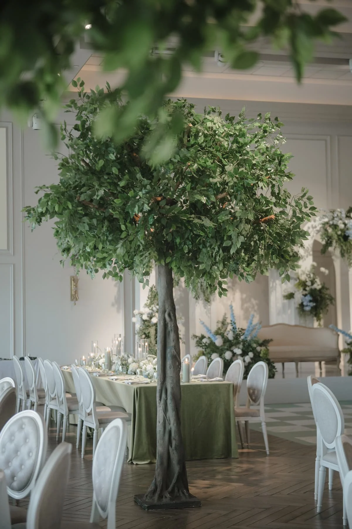 Indoor tree installation overlooking elegant reception tables with candlelight and floral décor at Ashika and Sagar's Arlington Estate wedding reception.