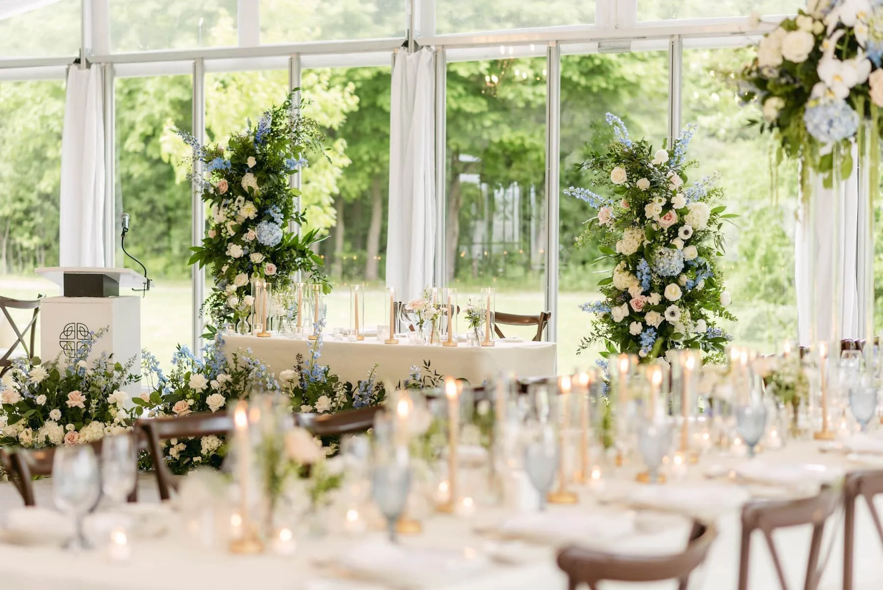 Garden-inspired sweetheart table with abundant blue and white floral arrangements at Harding Waterfront Estate.