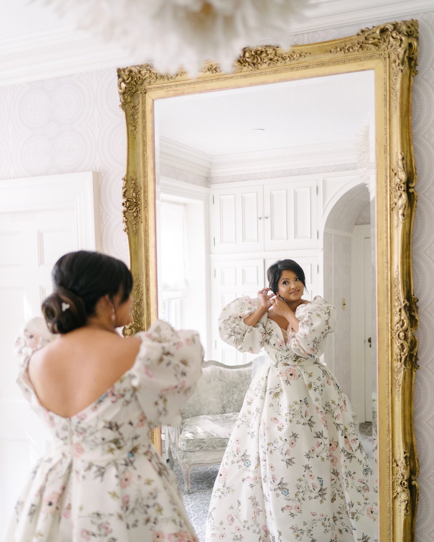 Bride reflected in a mirror while getting ready at Graydon Hall Manor before her wedding, planned by Events by Whim.