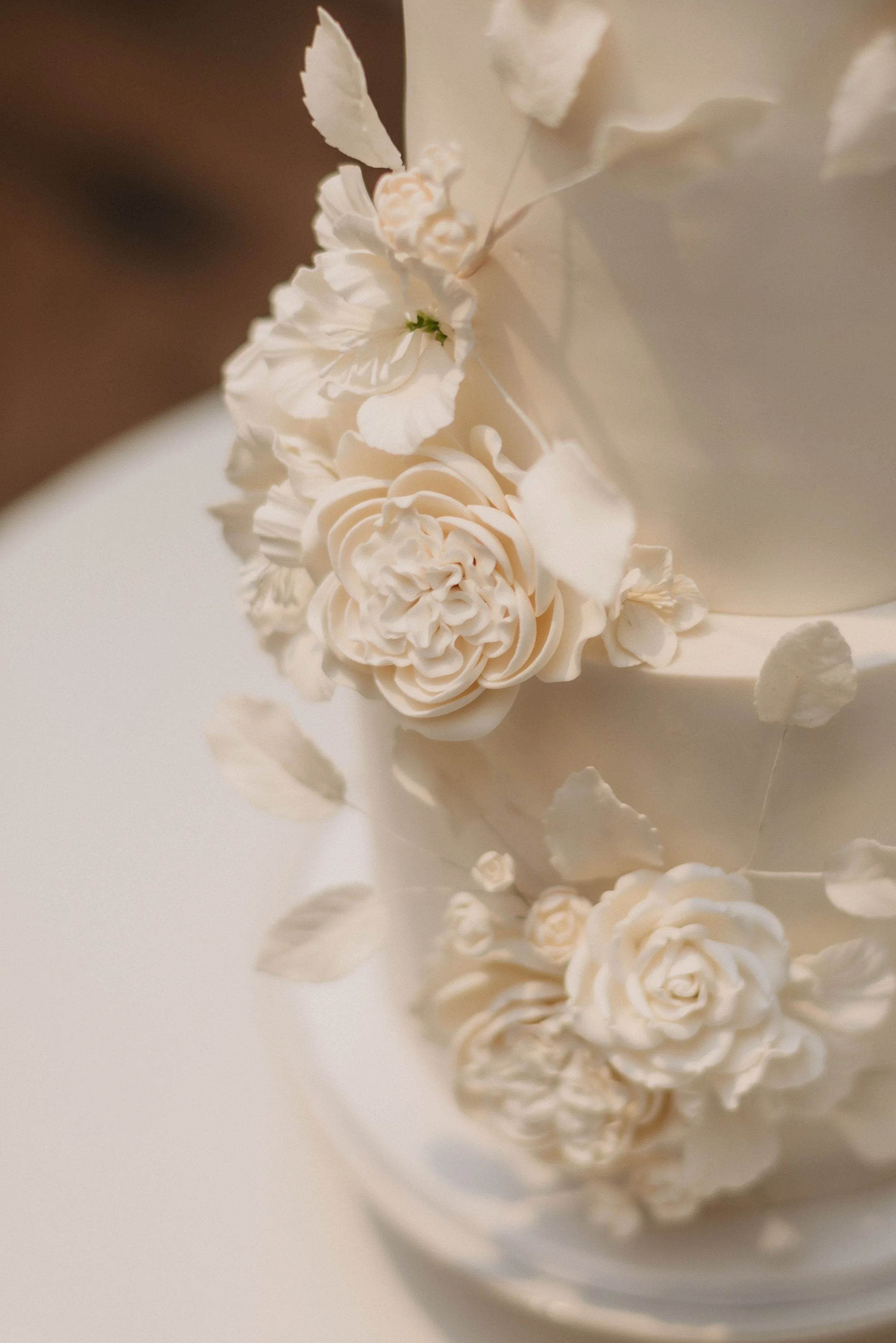 Elegant white wedding cake featuring handcrafted sugar flowers, designed for a luxury wedding planned by Events by Whim.