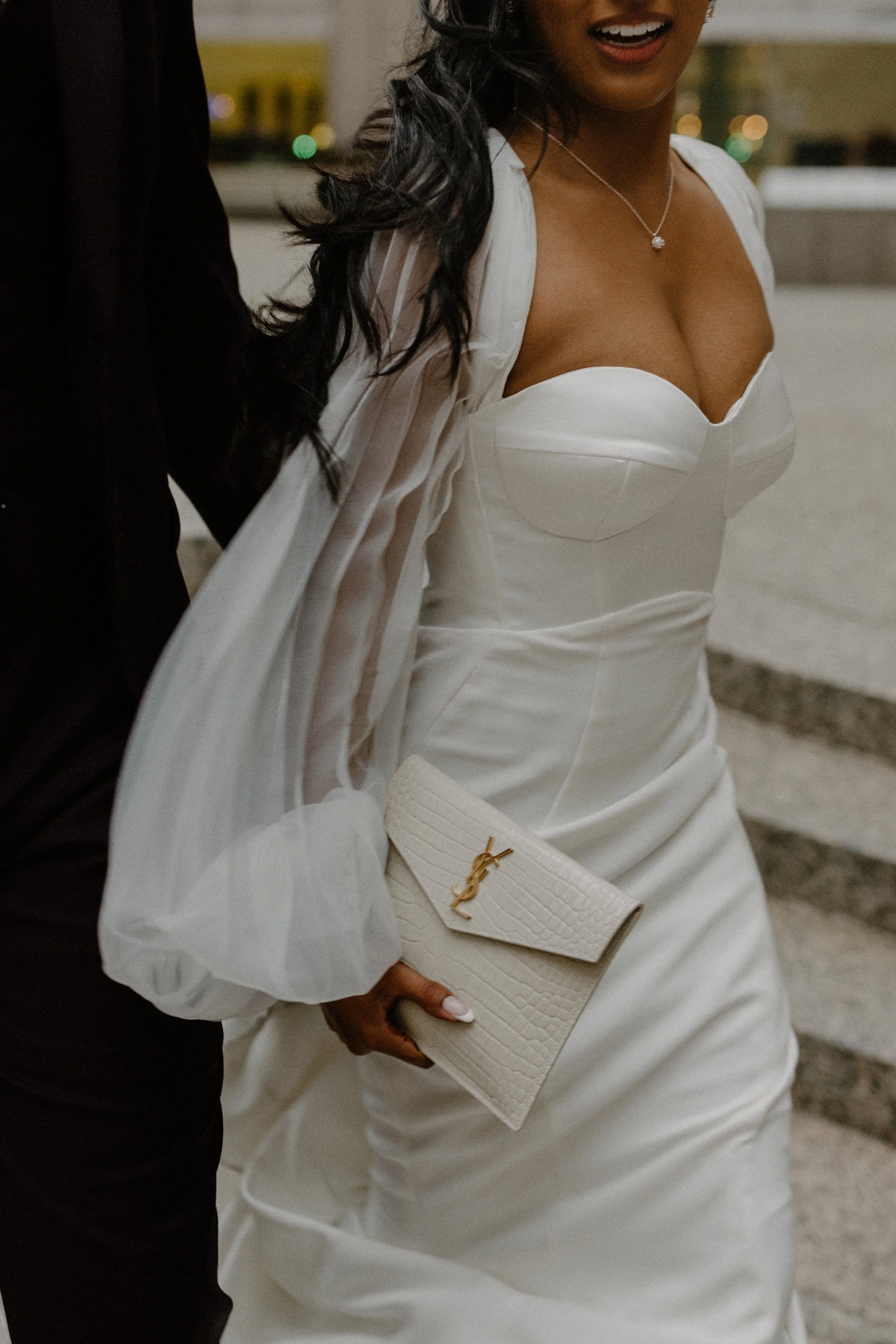 Bride holding a YSL clutch outside One King West during a luxury wedding planned by Events by Whim.