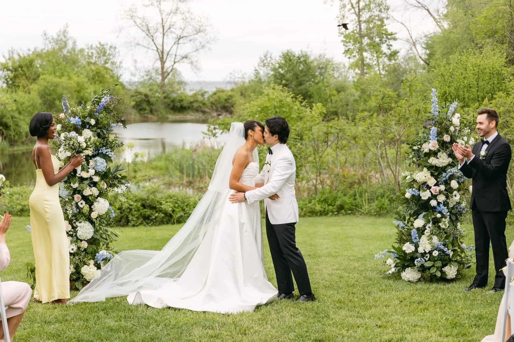 Bride and groom share their first kiss during an outdoor ceremony at Harding Waterfront Estate.