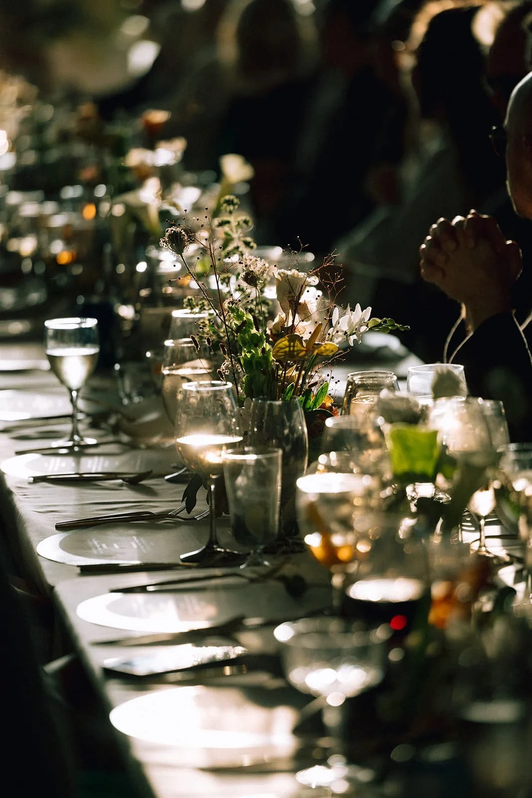 Custom table design featuring fruit, candles, ikebana and small floral arrangements and bespoke stationery during the wedding dinner reception at Lune 1860