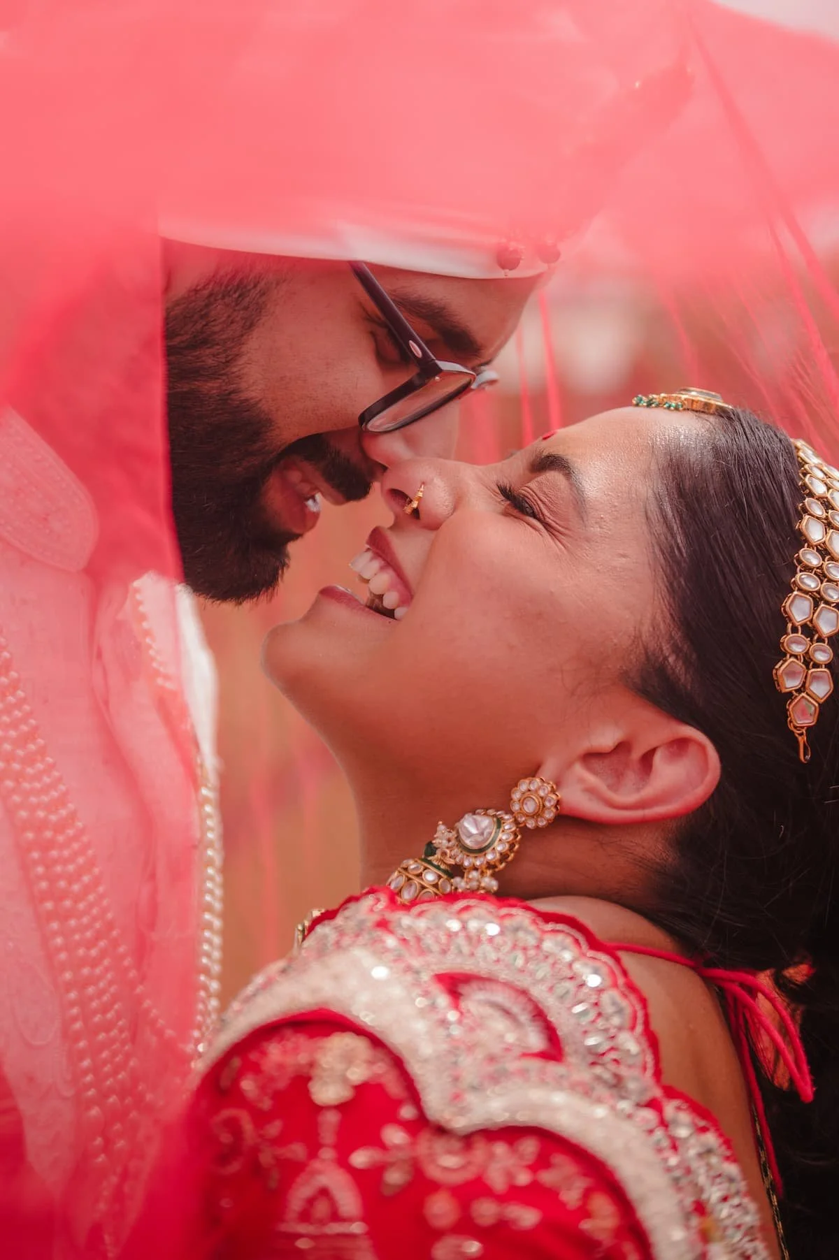 Ashika and Sagar share an intimate moment beneath the bride's red veil during portraits before their Hindu wedding ceremony at Arlington Estate.