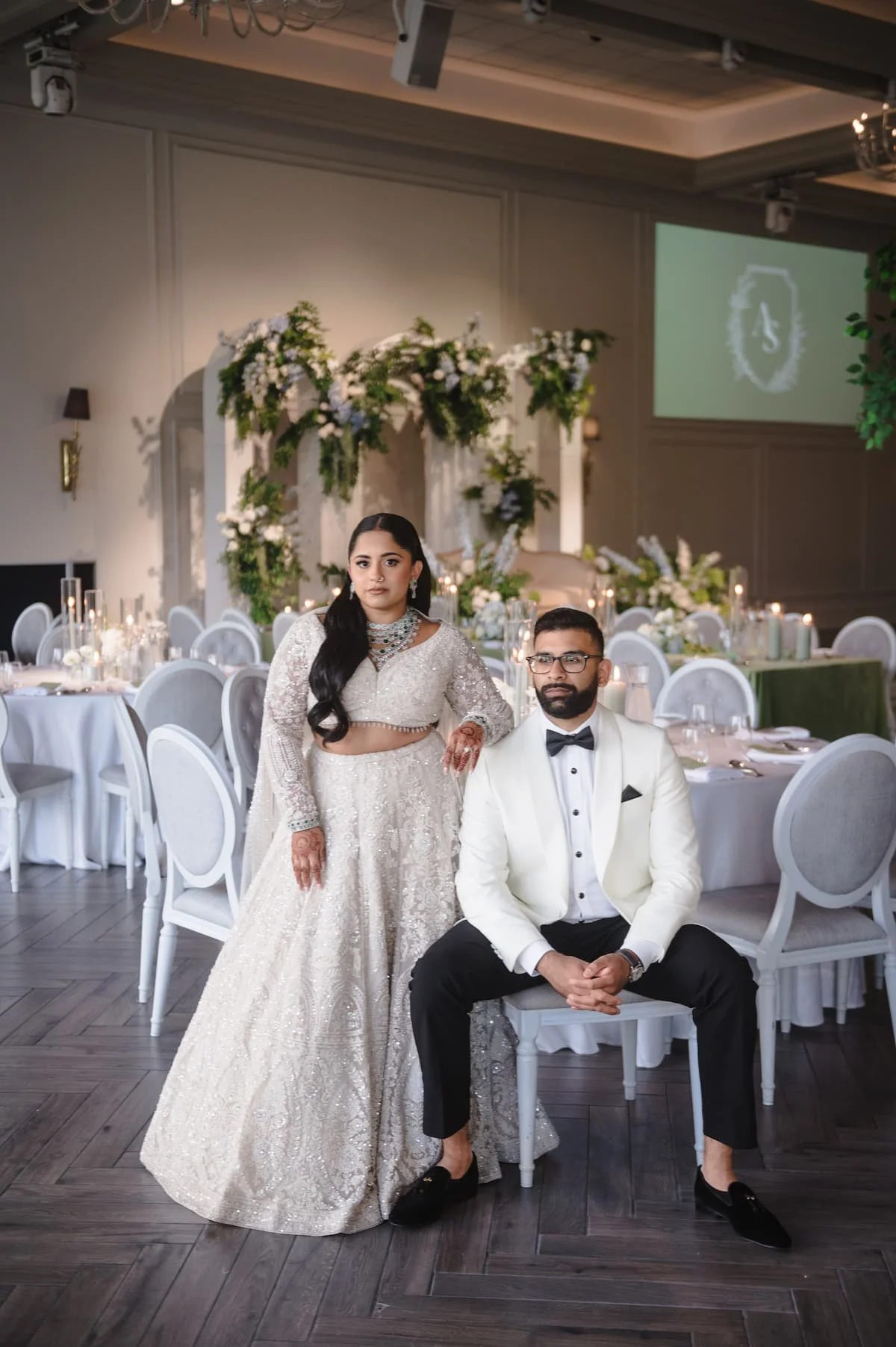 Bride and groom posing in their candlelit reception space at Arlington Estate during their South Asian wedding.