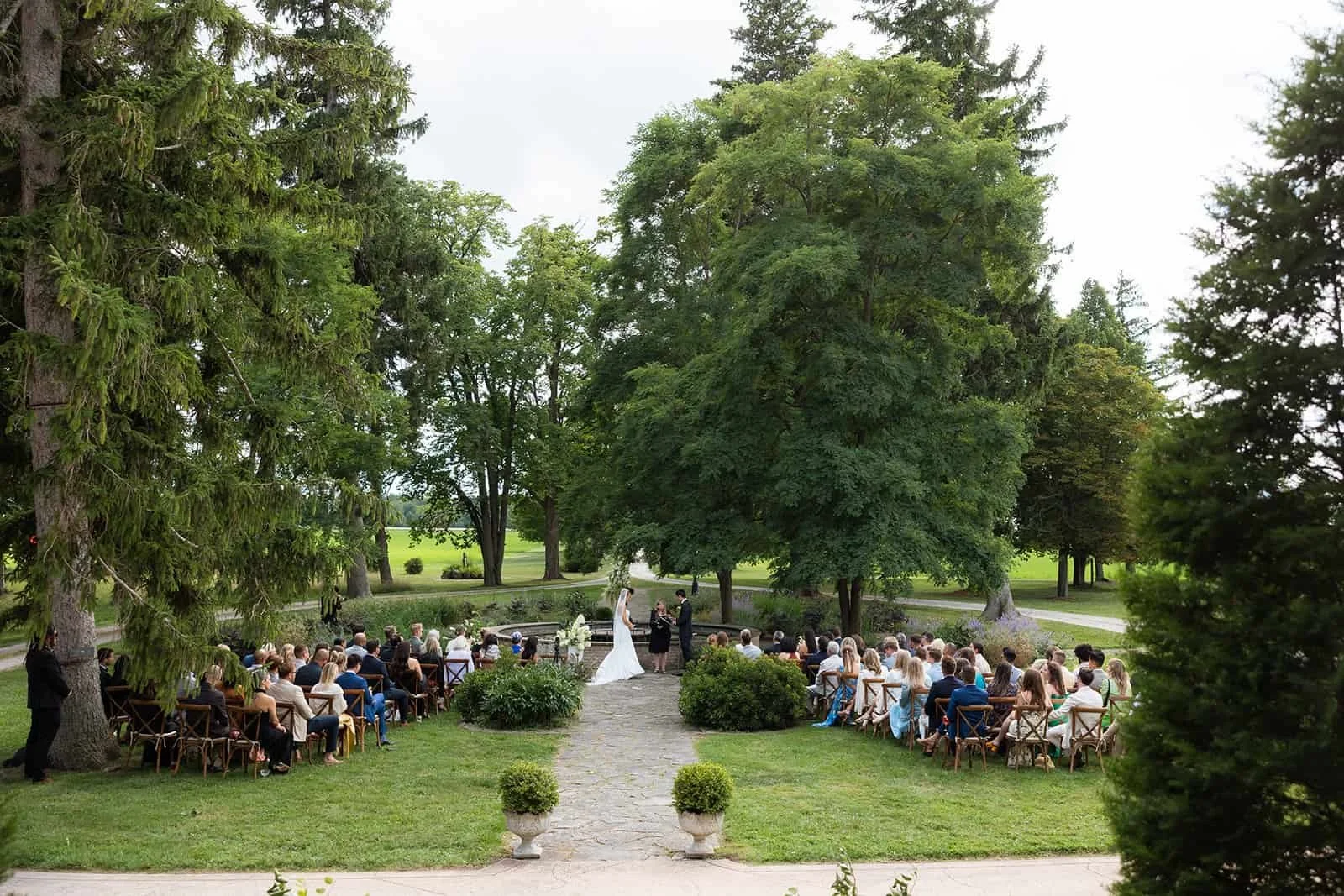 Couple exchanging vows during an outdoor wedding ceremony at Lune 1860 in Ontario.
