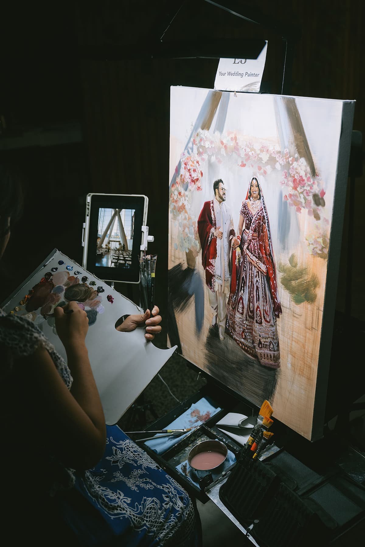 Live wedding painter creating a portrait of the bride and groom during their luxury wedding reception at Ricarda's Toronto.