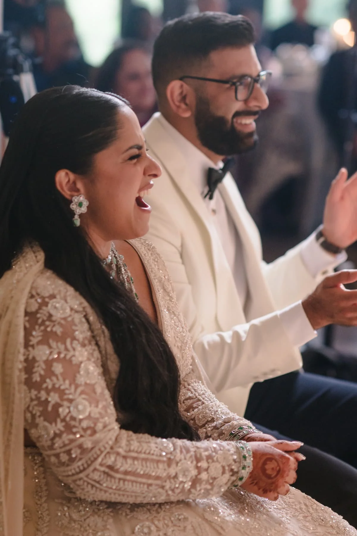 Ashika and Sagar laugh together during their wedding reception at Arlington Estate while enjoying the evening's speeches and entertainment.