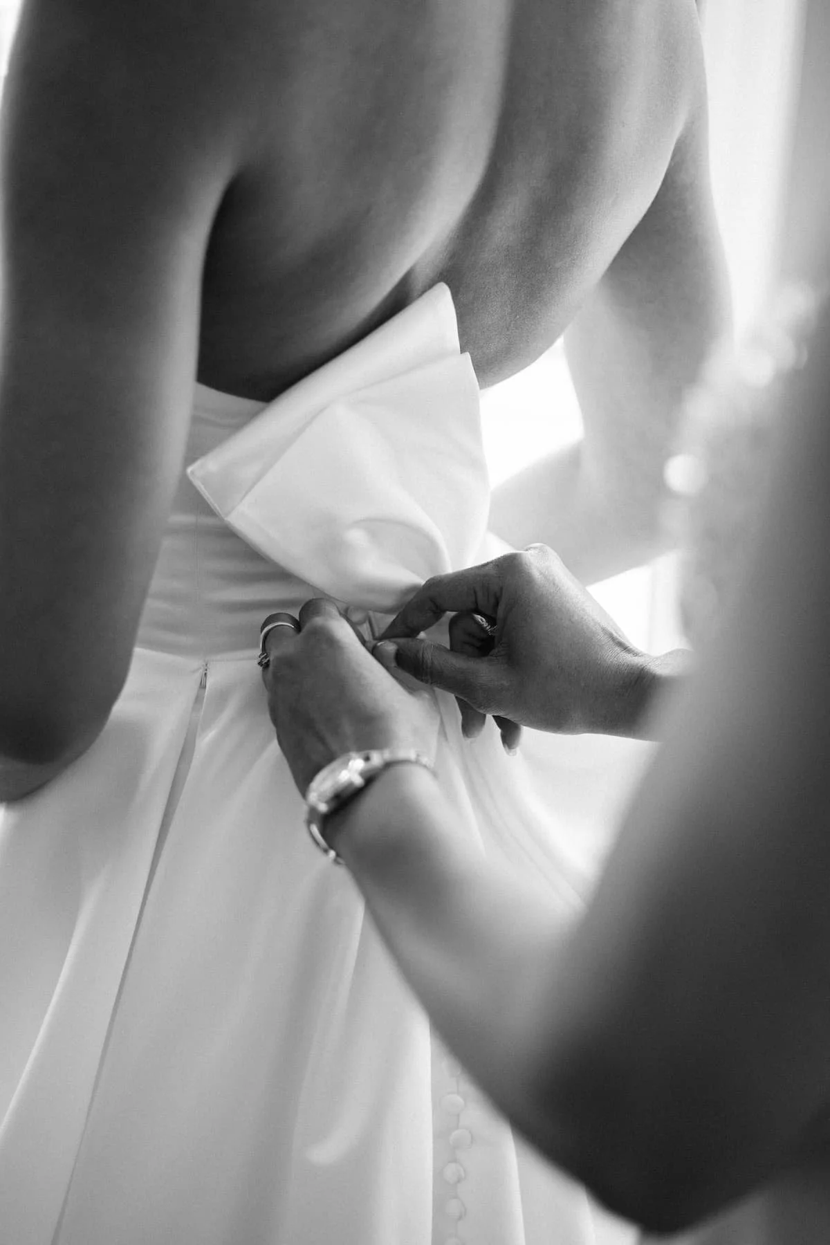 Bride gets into her wedding gown before her ceremony at Harding Waterfront Estate in Mississauga, Ontario.