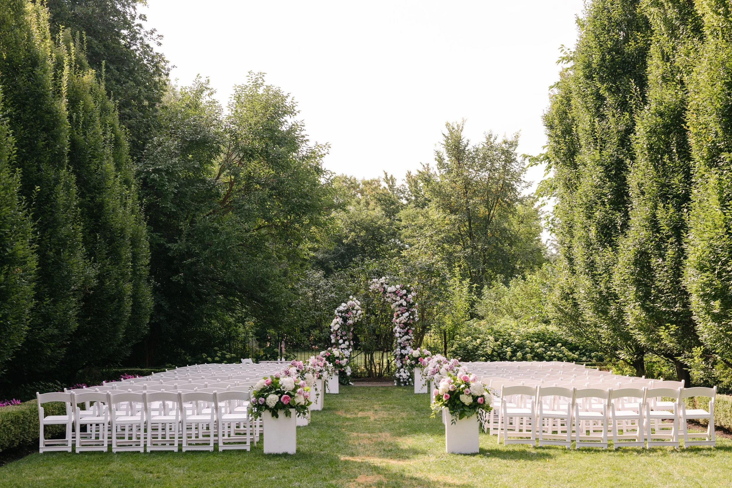 Lush floral outdoor wedding ceremony at Graydon Hall Manor in Toronto
