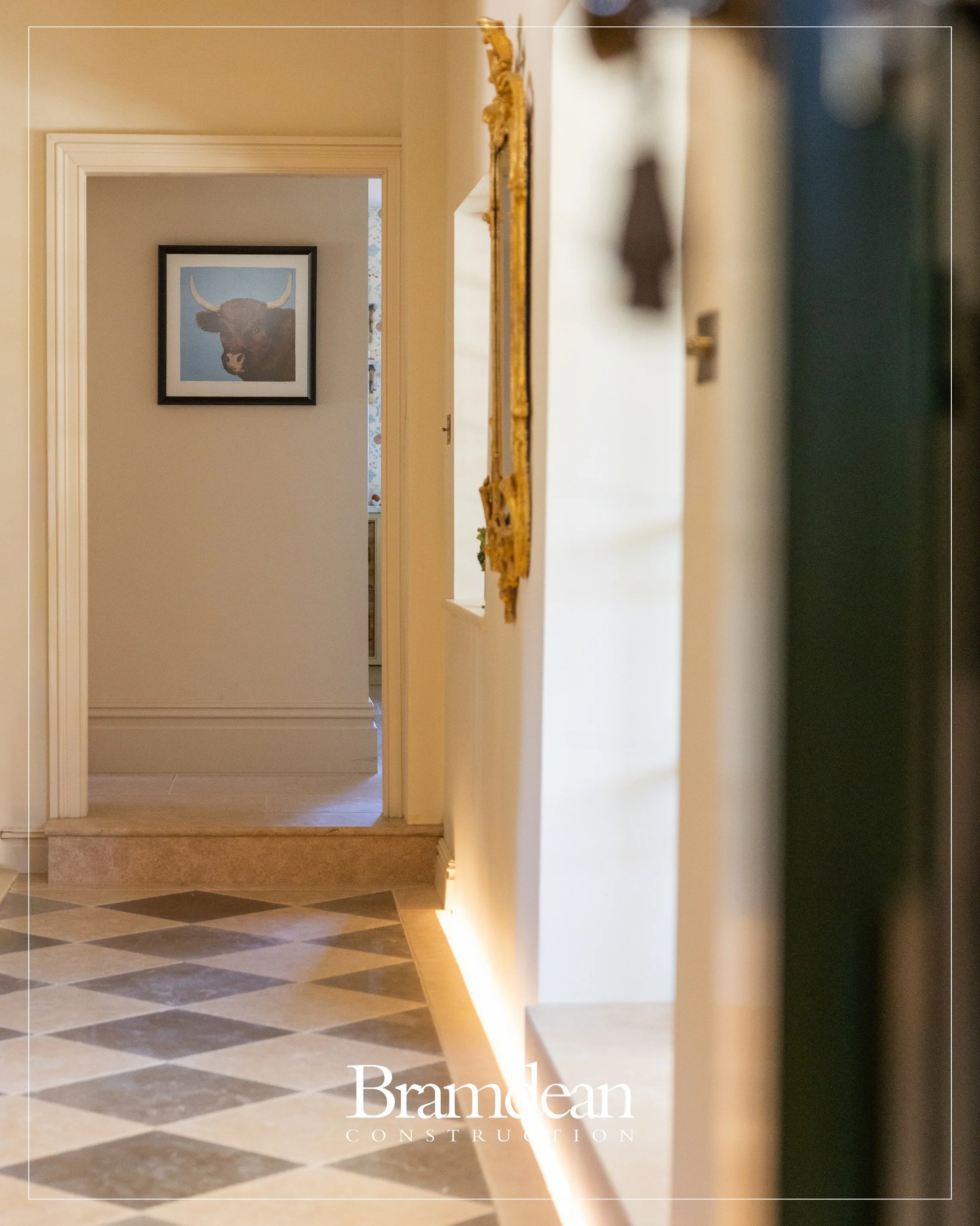 Recessed low-level lighting has been carefully integrated along the base of the wall, casting a warm wash of light across the stone floor without the need for visible fittings.

It&rsquo;s a contemporary detail sitting alongside more traditional mate