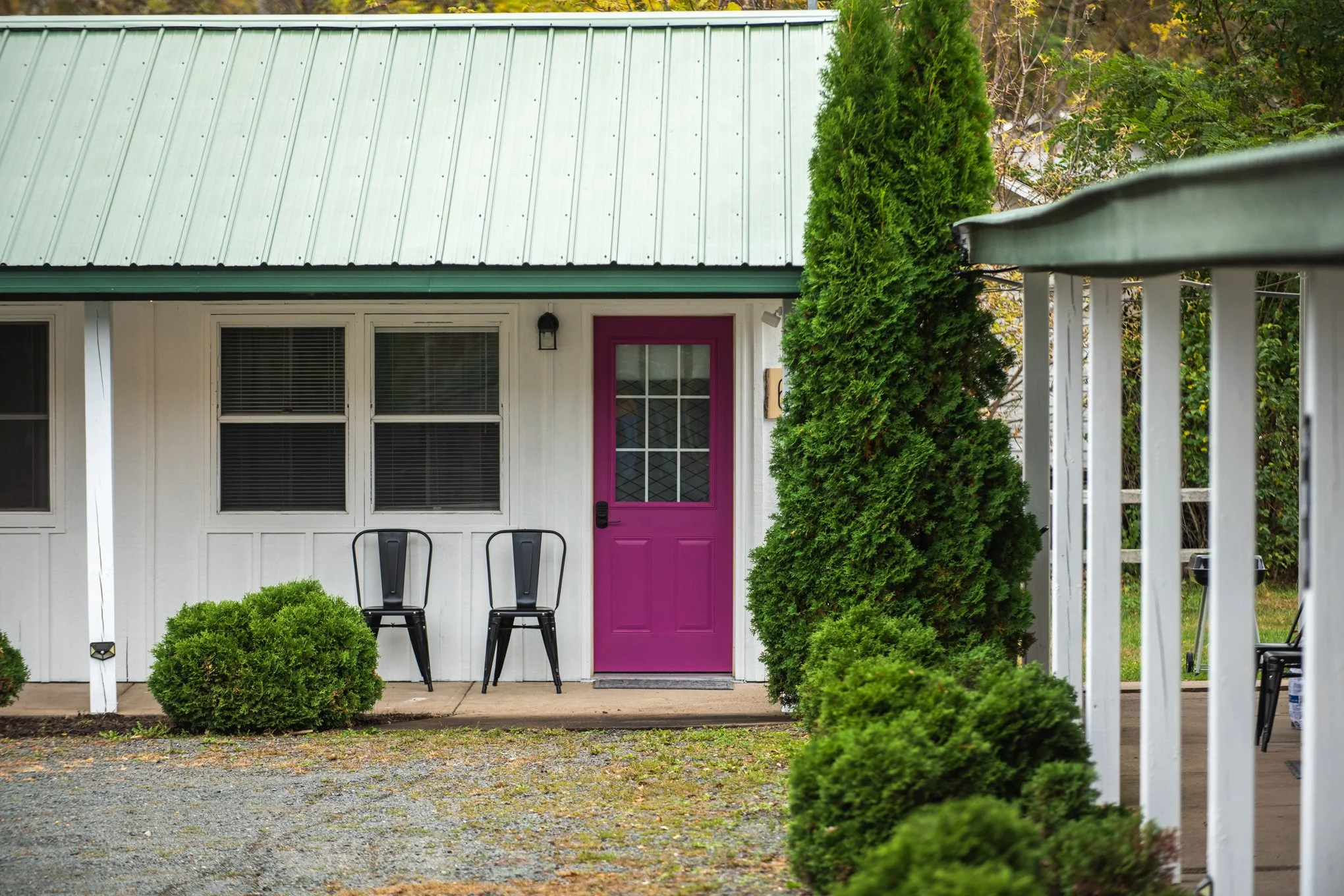 Bright pink door with windowpanes and smart lock, beside a window and outdoor light.