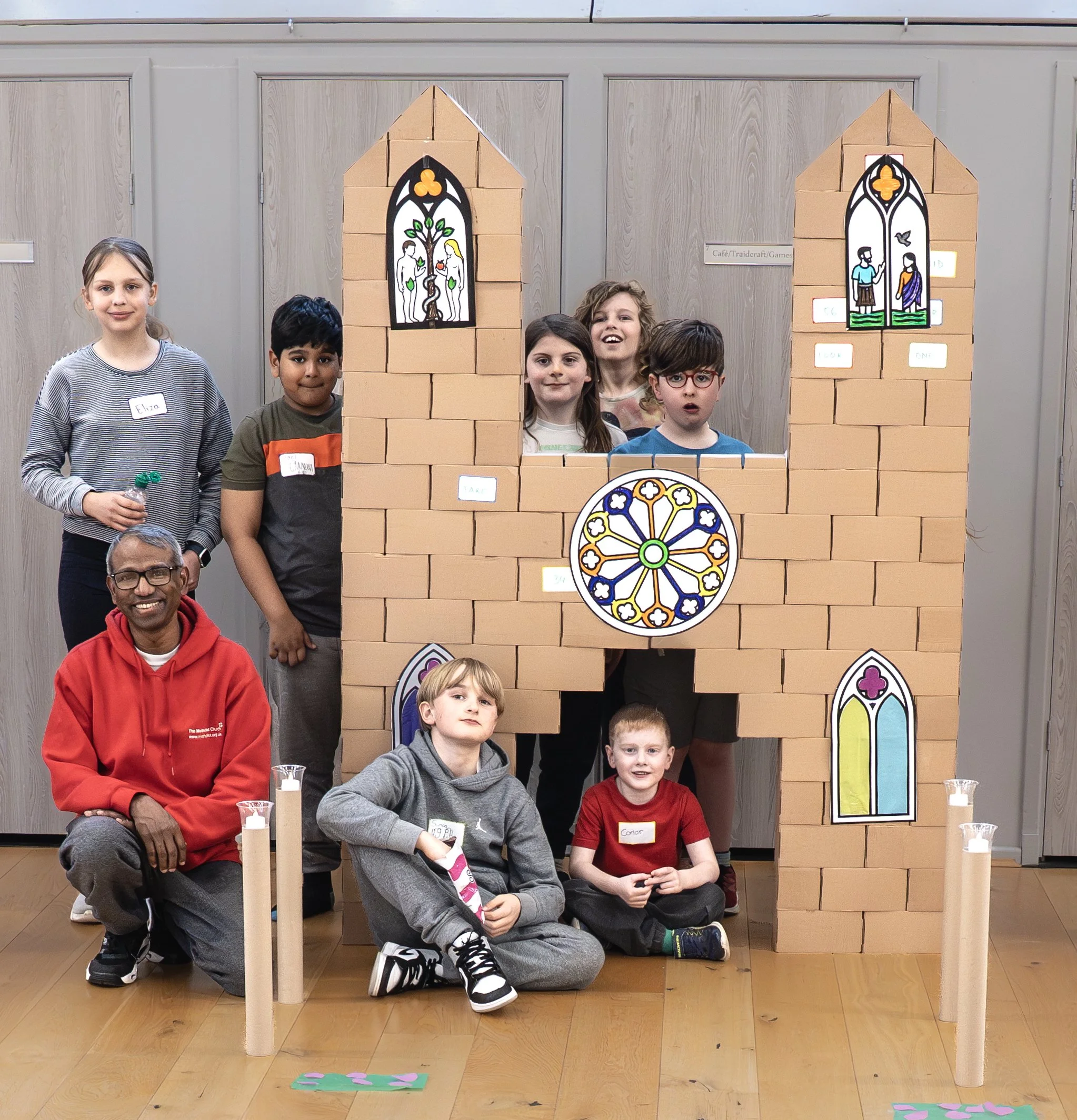 Children standing in front of a church that they built in the game