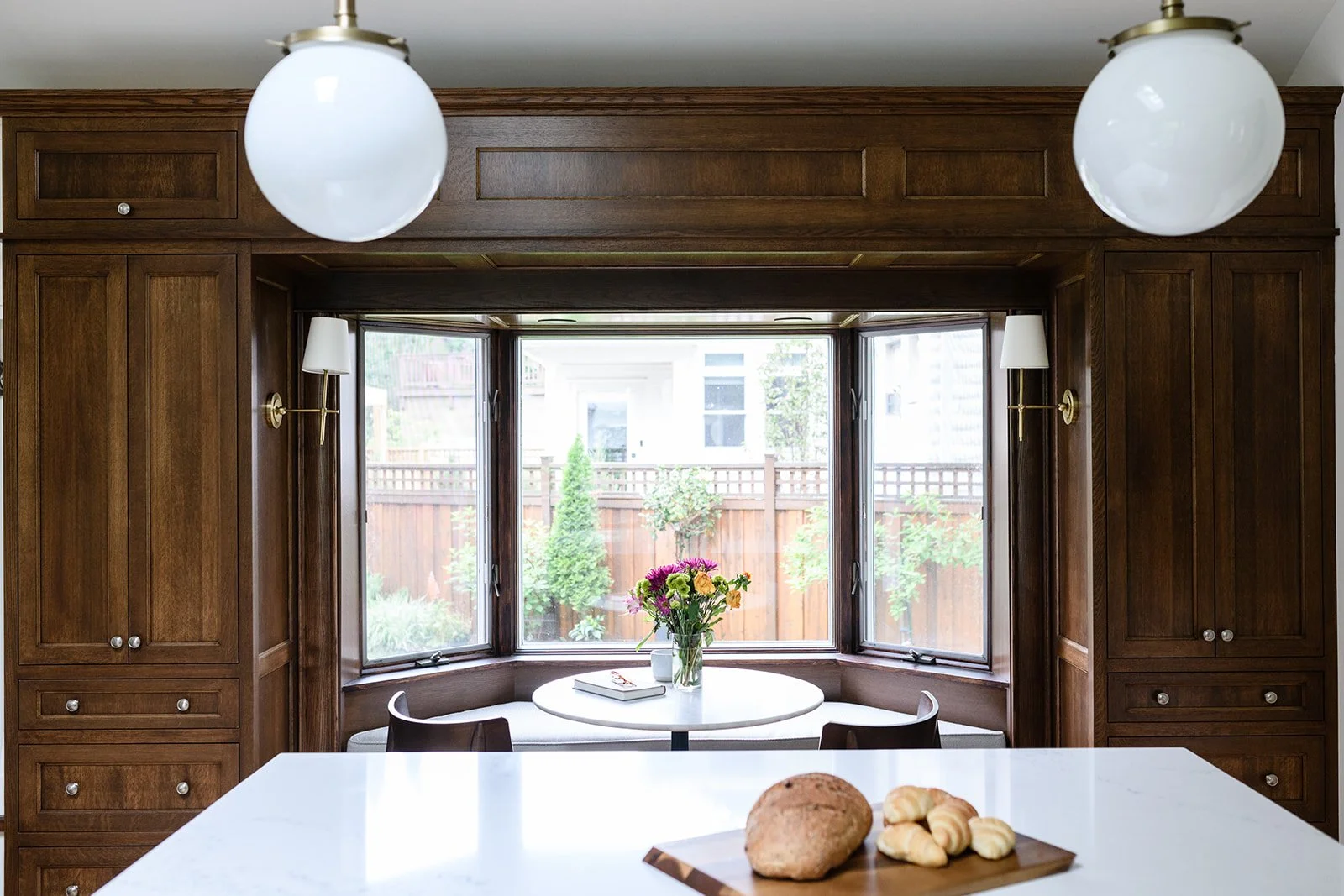 Built in bench around bay window. A perfect spot for families to gather at the end of a long day in this Minneapolis Kitchen designed by Victoria Johnson Interiors