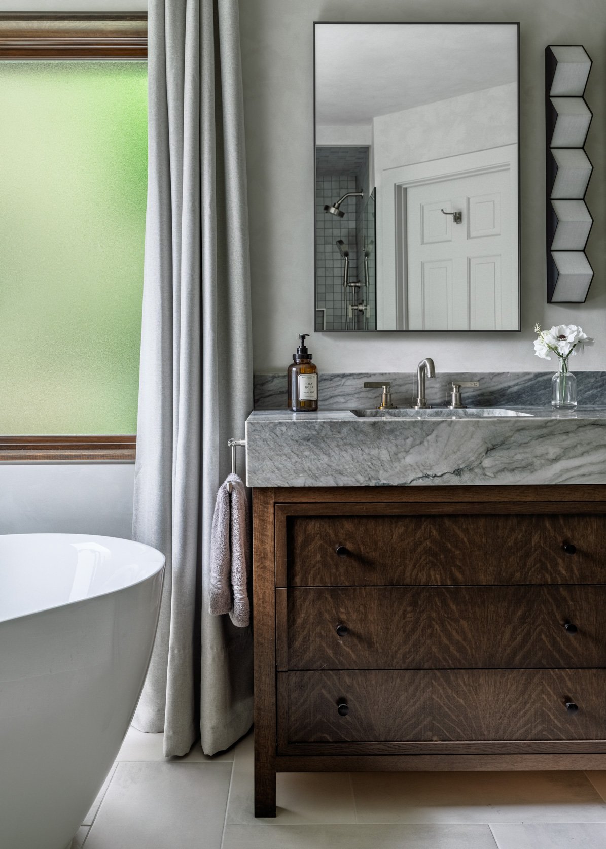 Detail of dark oak inset bathroom vanity with mittered quartz countertop