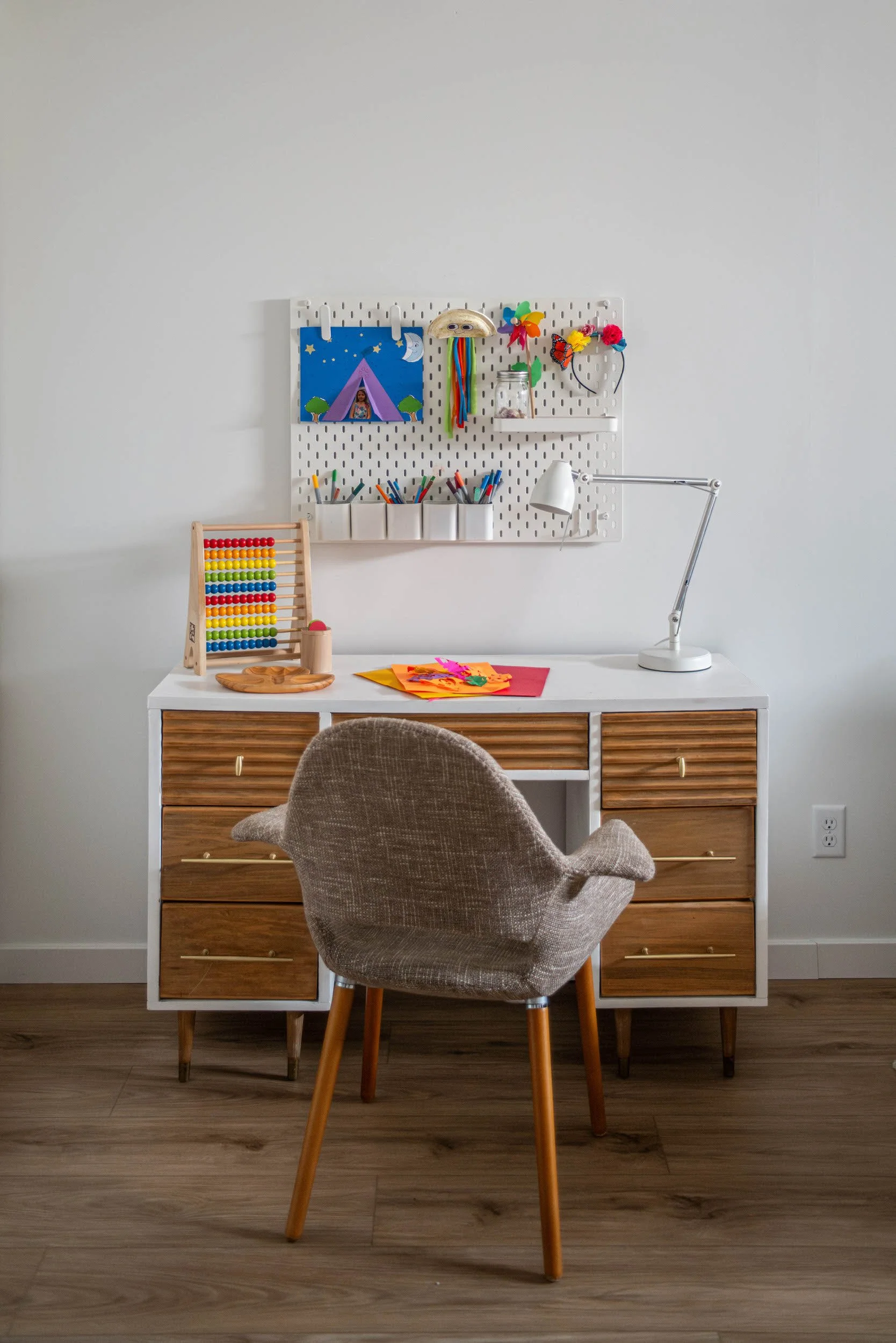 Kids arts and craft area with mid-century modern desk and chair and IKEA peg board