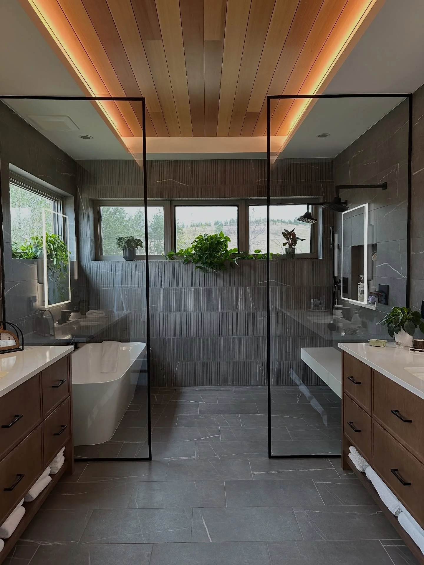 I can&rsquo;t stop staring at this view.
This primary bathroom came together in a way that feels both bold and calming, for the homeowners it becomes a sanctuary. 

The wood ceiling glow. The texture in the wall tile. The dark framed glass. The clean