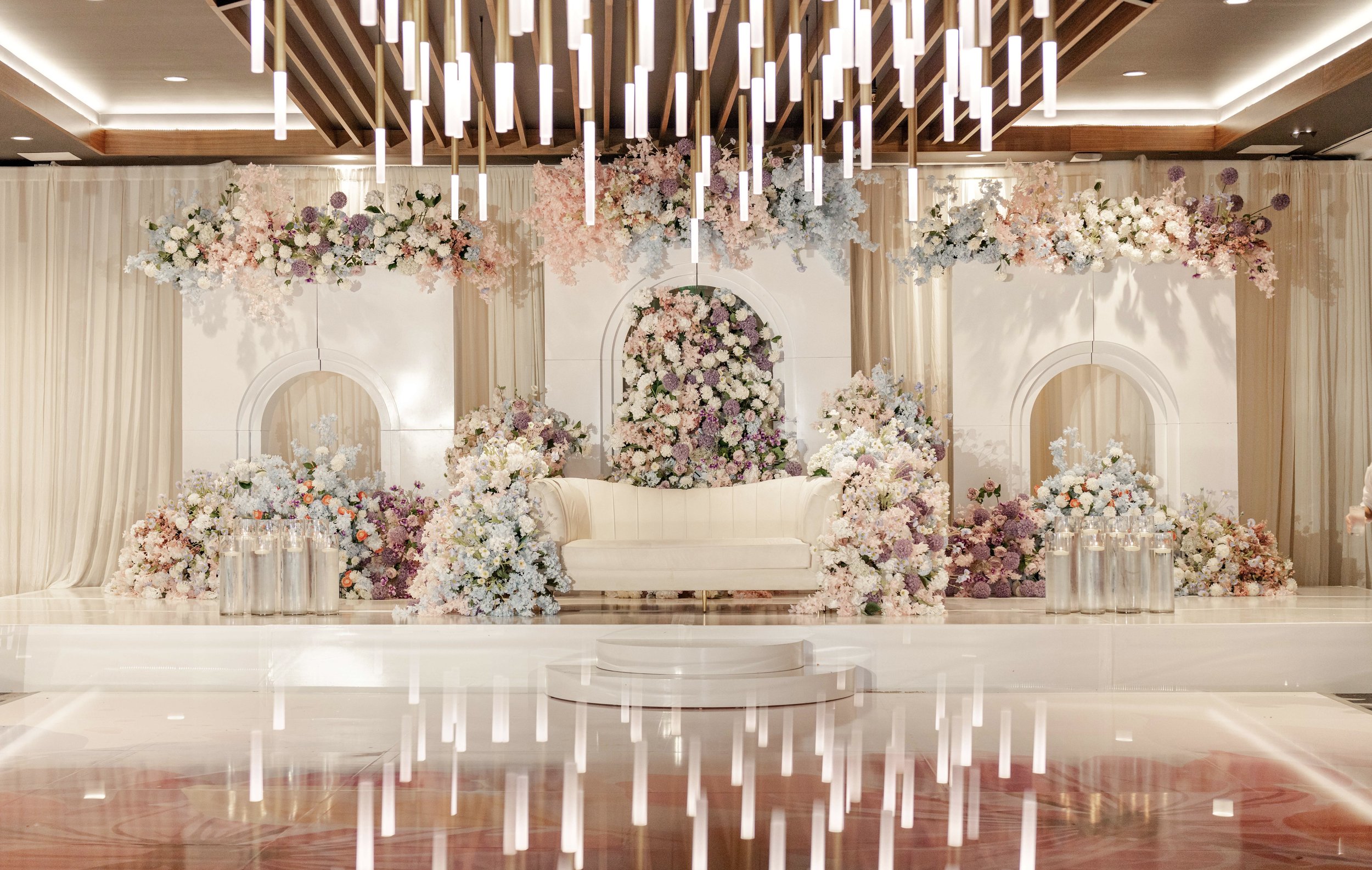 Indian Wedding Planner Boston Massachusetts. Wedding Design Company Boston Massachusetts. Sangeet Decor Marriott Springfield Massachusetts New England. Indian Wedding Decorator White Arches with light floral in purple, blue, blush pink, peach and whi