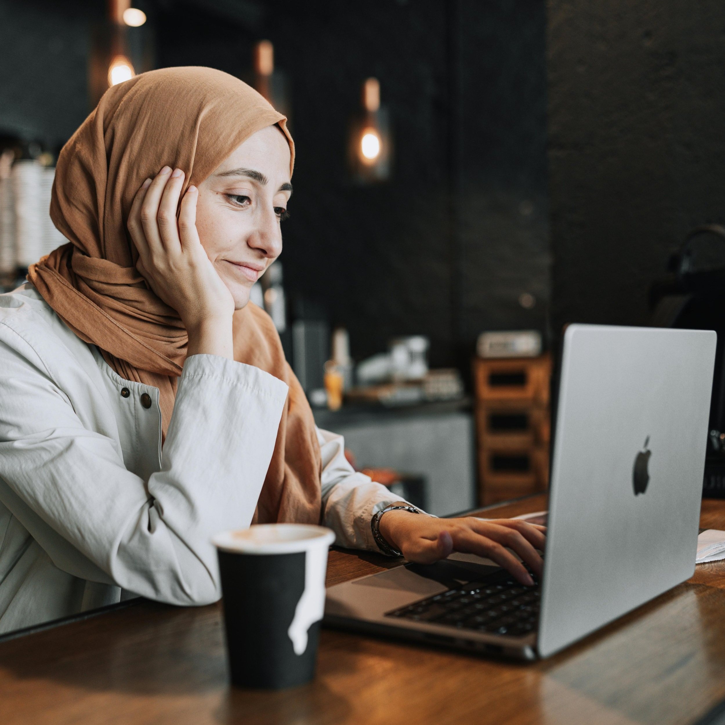 Woman on laptop in cafe. Photo by Ahmed ツ: https://www.pexels.com/photo/woman-in-headscarf-working-on-laptop-at-cafe-17564434/