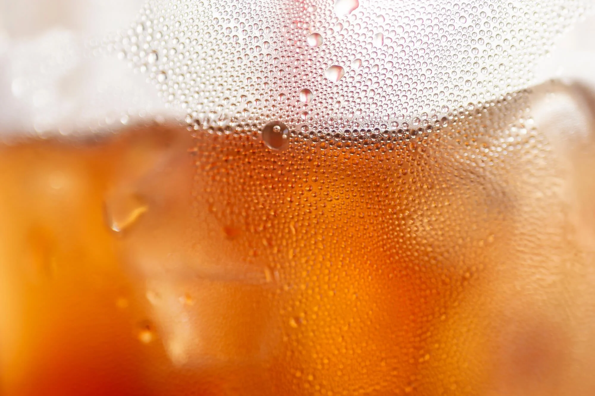 Close-up of a glass of beer with condensation droplets on the surface.