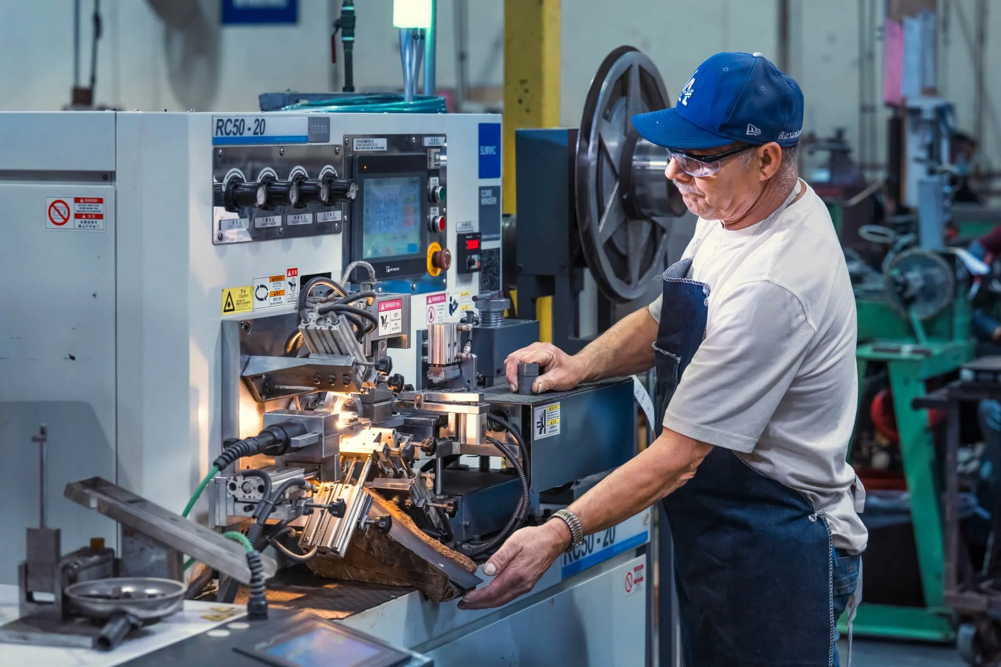 Worker operating a binding machine at a manufacturing facility in San Diego County–Ed Carreon Photography