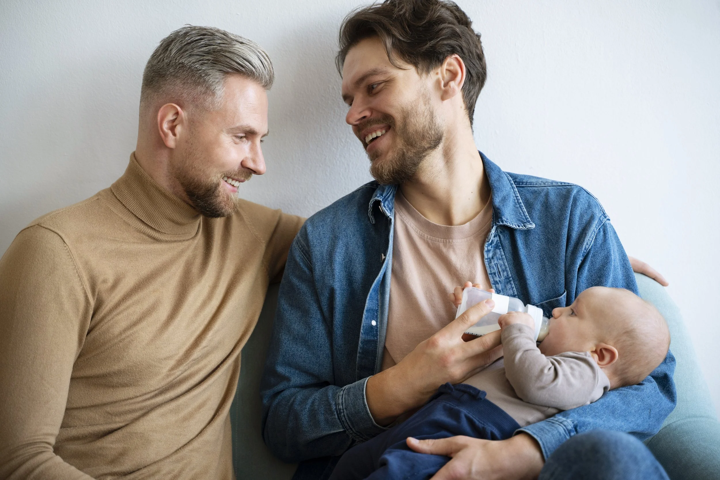 Two parents bottle-feeding newborn baby