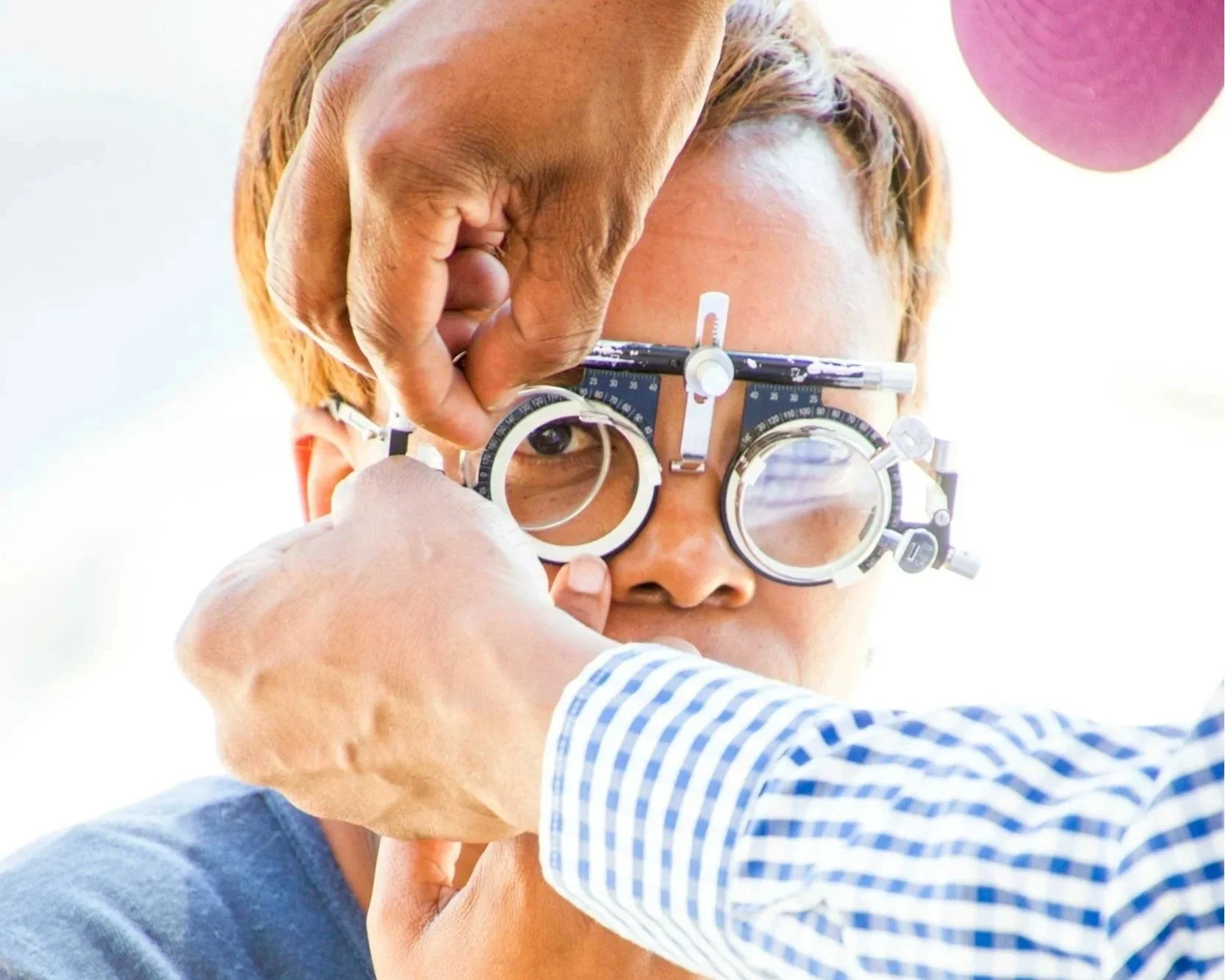 Optometrist performing an eye exam using a phoropter during a patient vision test